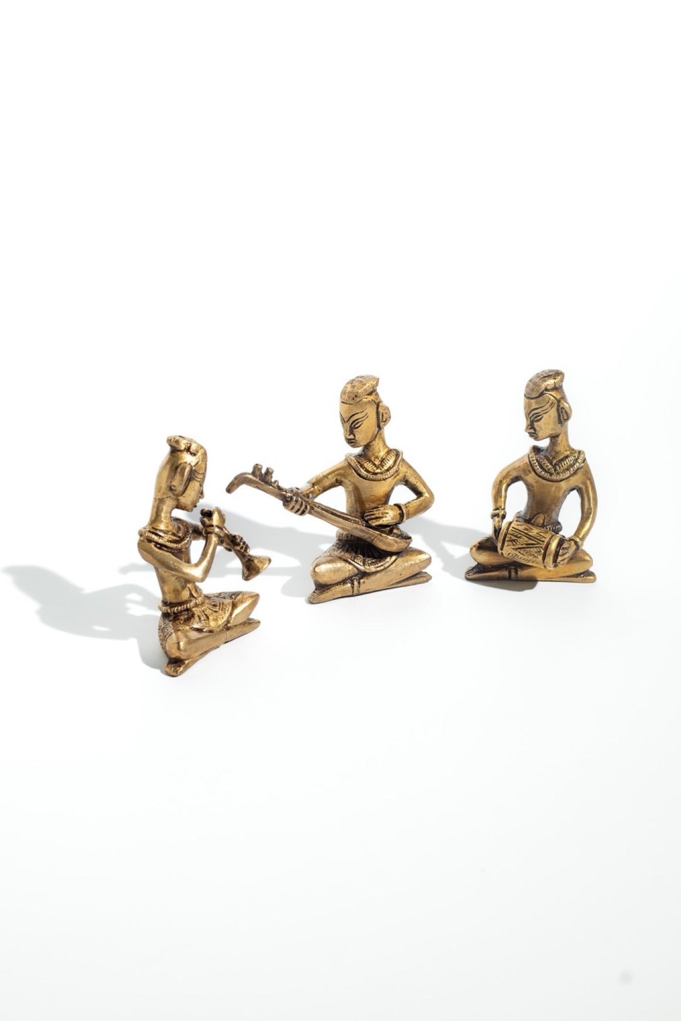 Three gold-colored figurines of musicians on a white background