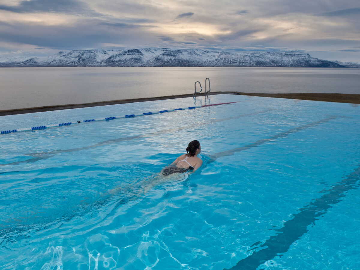 Steam rising from an outdoor geothermal pool in the Laugardalur valley in Reykjavik on a cold afternoon