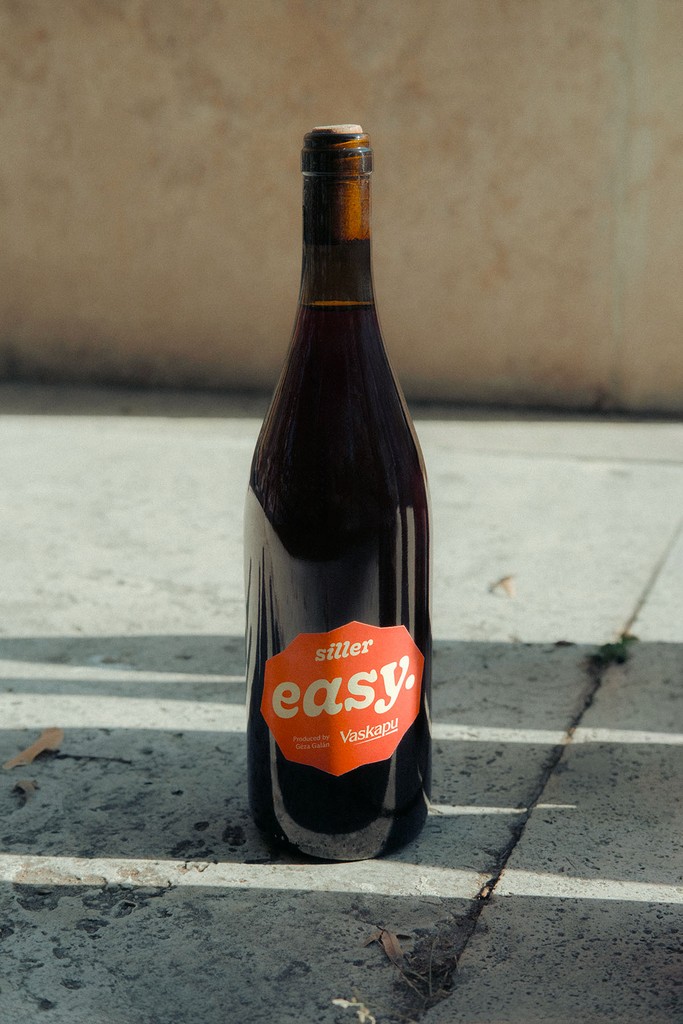 Vaskapu “easy.” siller wine bottle with orange label, designed by Marcell Kazsik — part of the winery’s playful, youthful sub-line that celebrates approachability and experimental design.