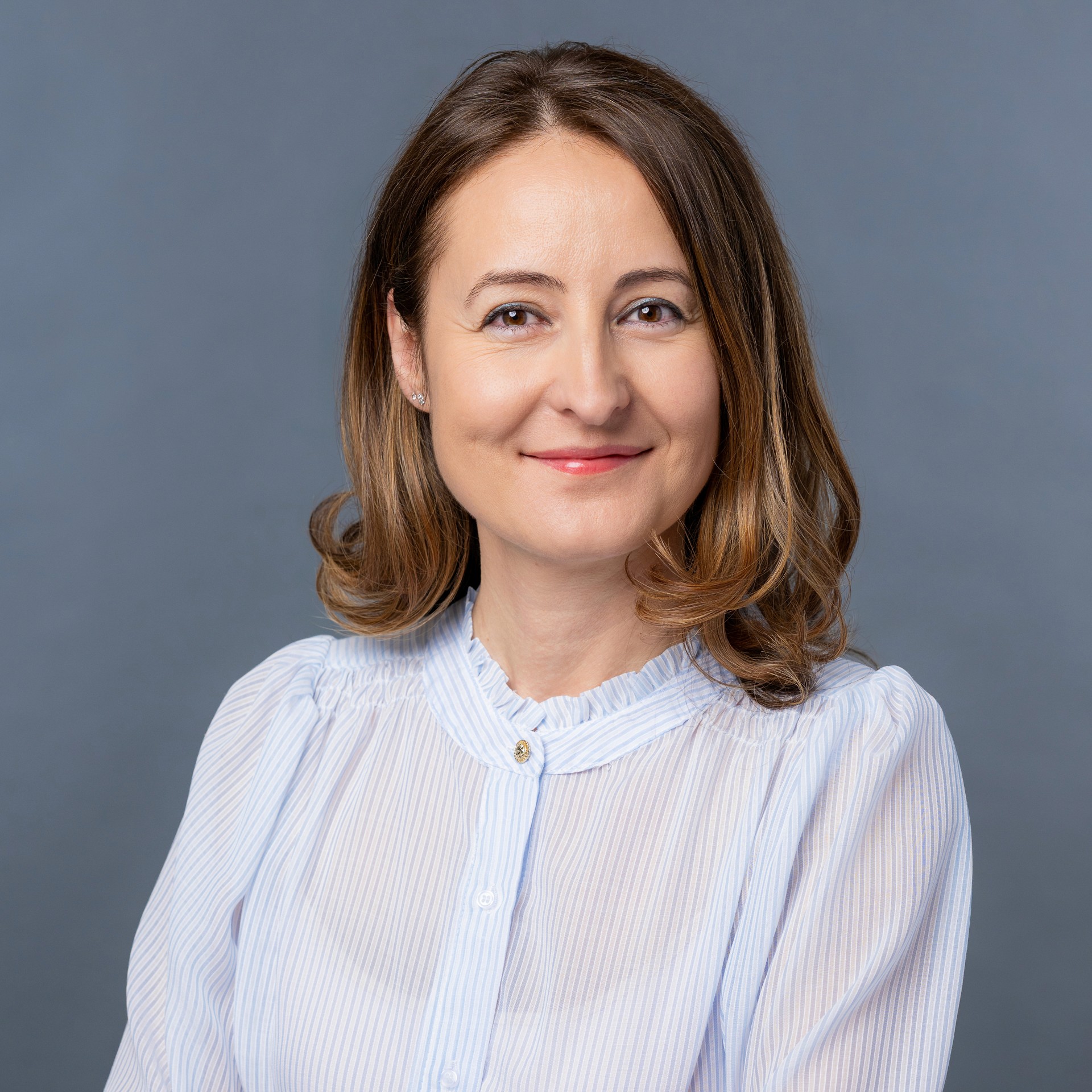 Professionelles Bewerbungsfoto einer Frau mit hellem Outfit und freundlichem Ausdruck, Business Portrait aus Zürich