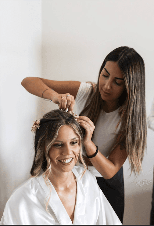 A woman lying down in a spa setting, relaxing with her eyes closed. Sunlight streams through blinds, casting striped shadows on her face. The scene conveys a sense of serenity and well-being.
