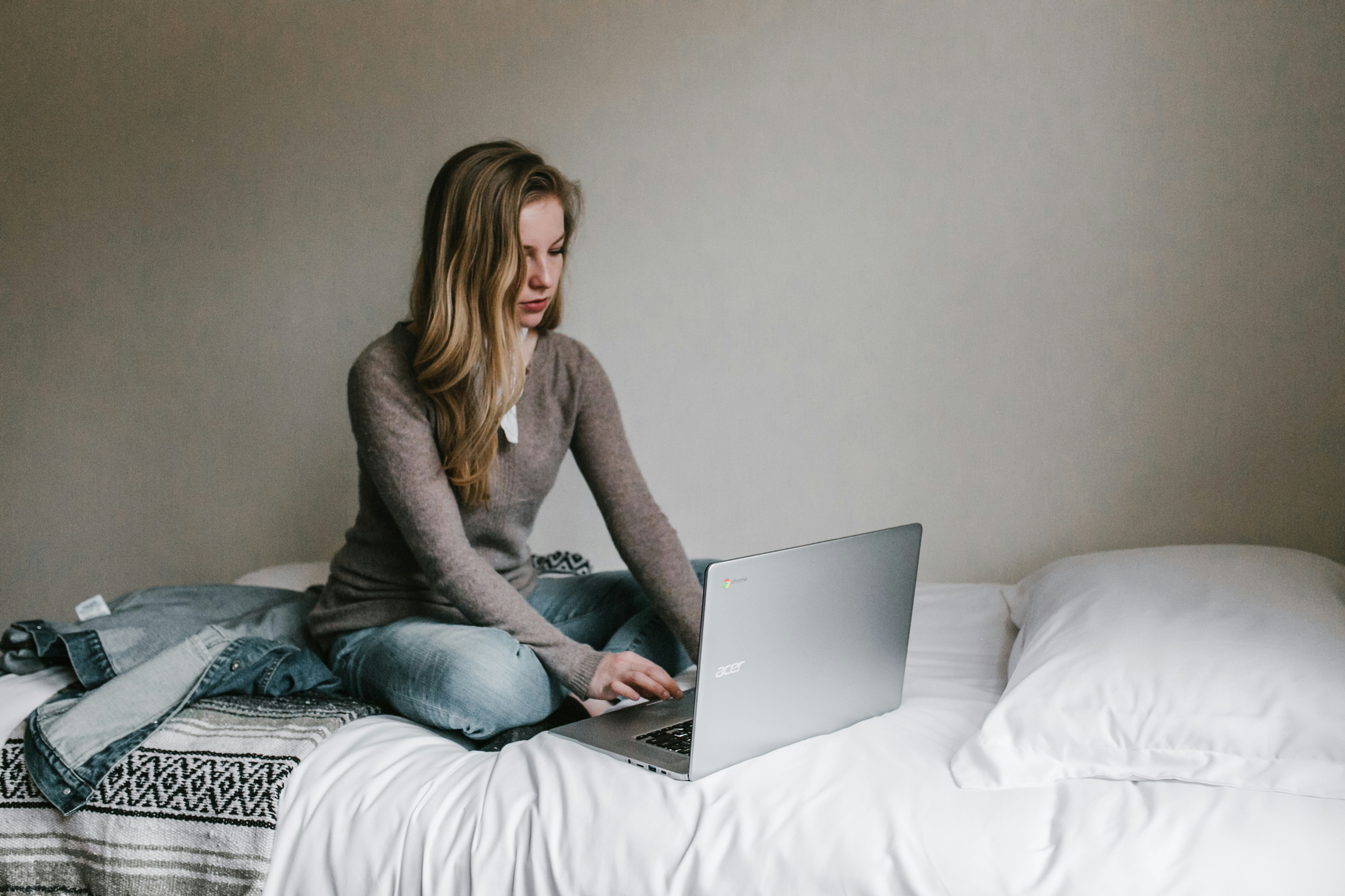 woman sitting on bed and working - Free Email Management Software