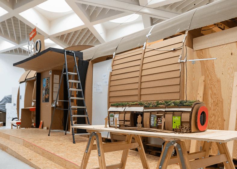 Ein kleines Maßstabs-Modell vor einem großen 1:1 Modell, aufgebaut in der Halle von Design for Human Nature.