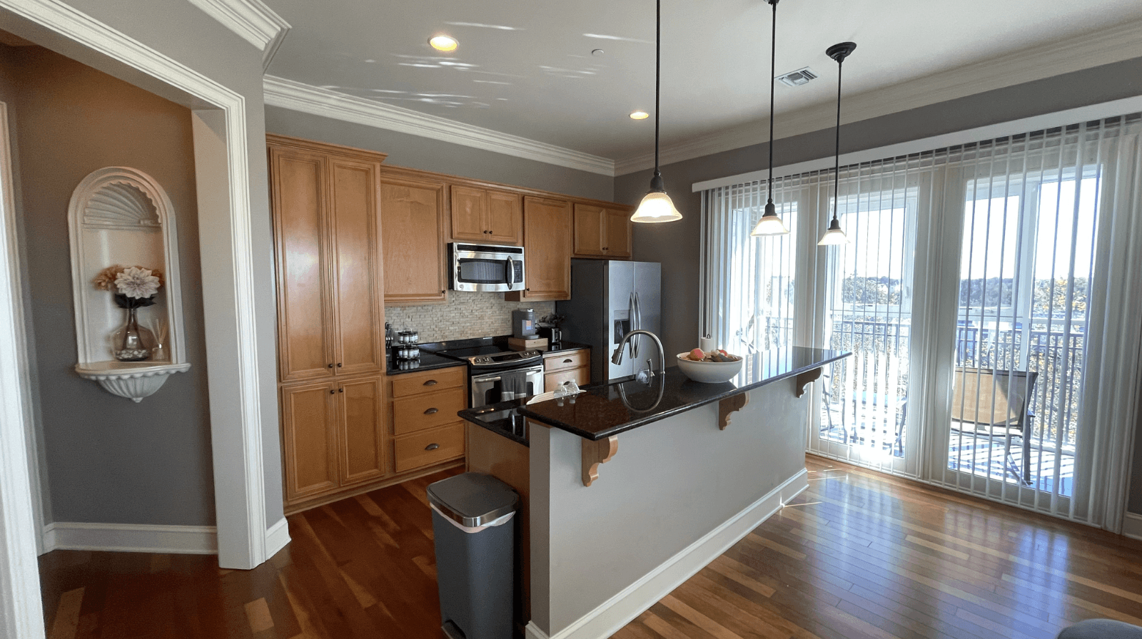 Bright, modern kitchen with granite counters and direct balcony access, offering a comfortable and convenient living space.