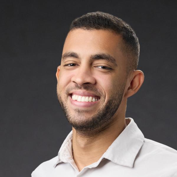 a man with a goatee smiles at the camera