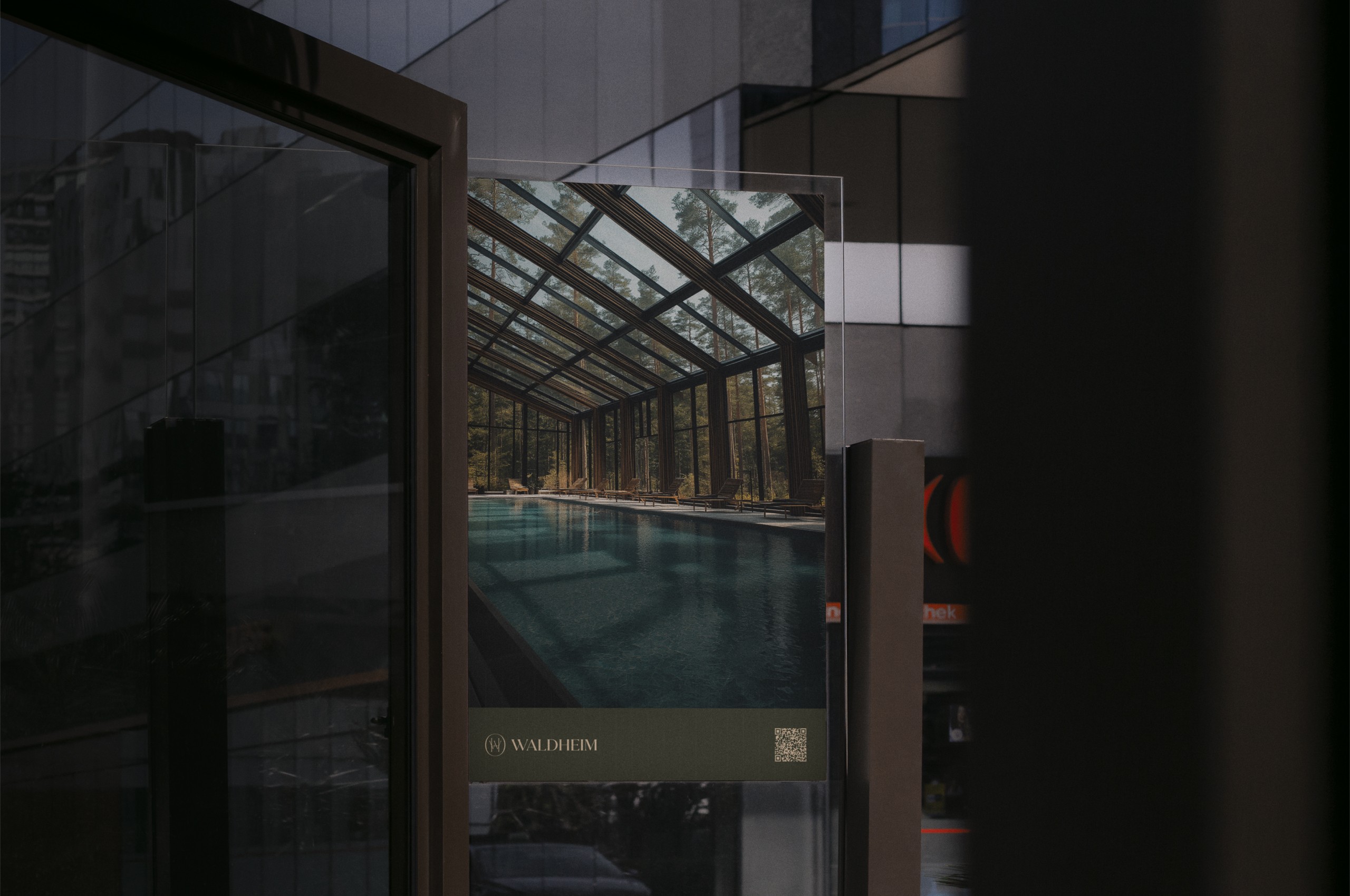Billboard com imagem da fachada do hotel e moldura da marca Waldheim na base.