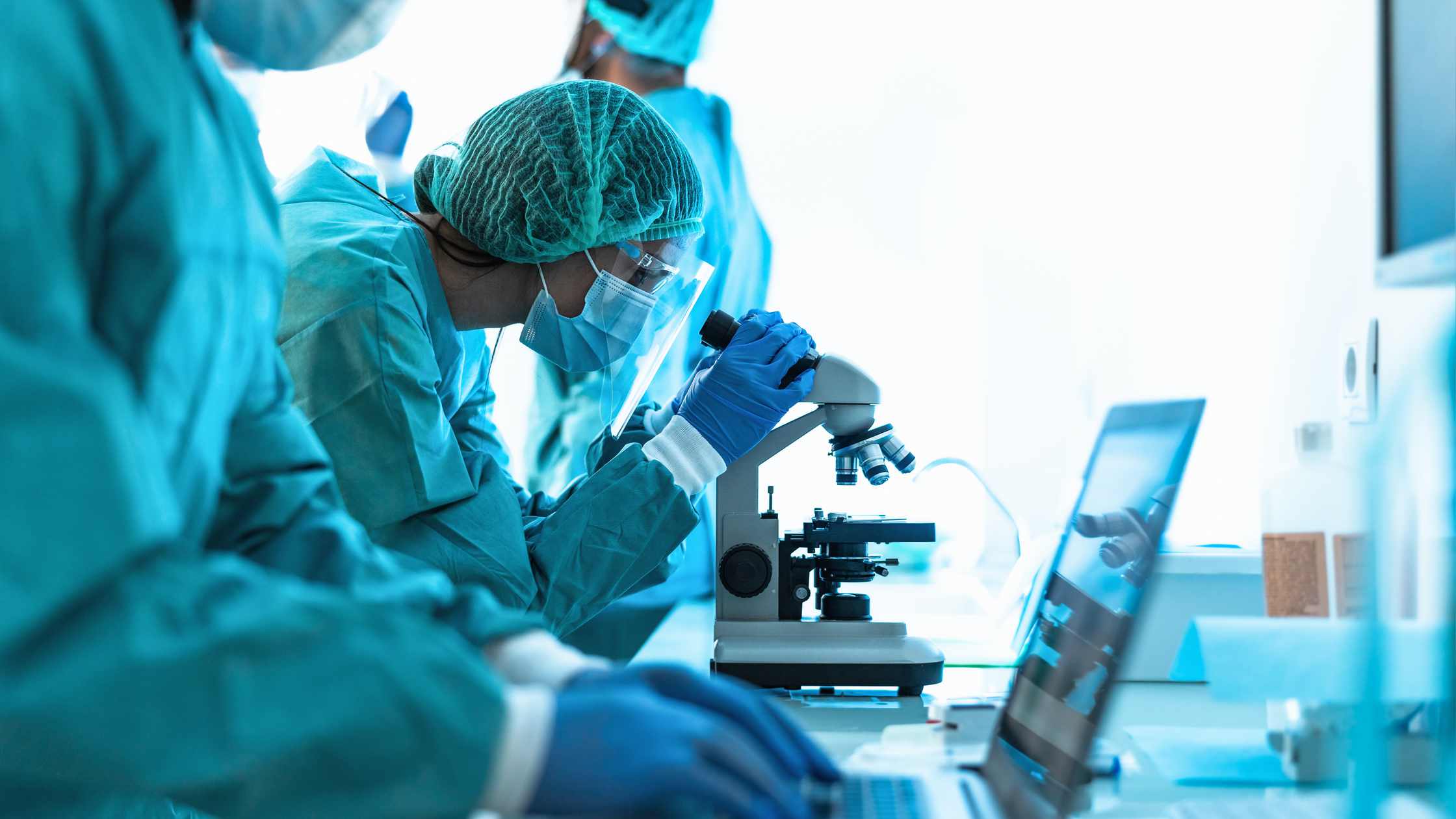 As cientist looking through a microscope.