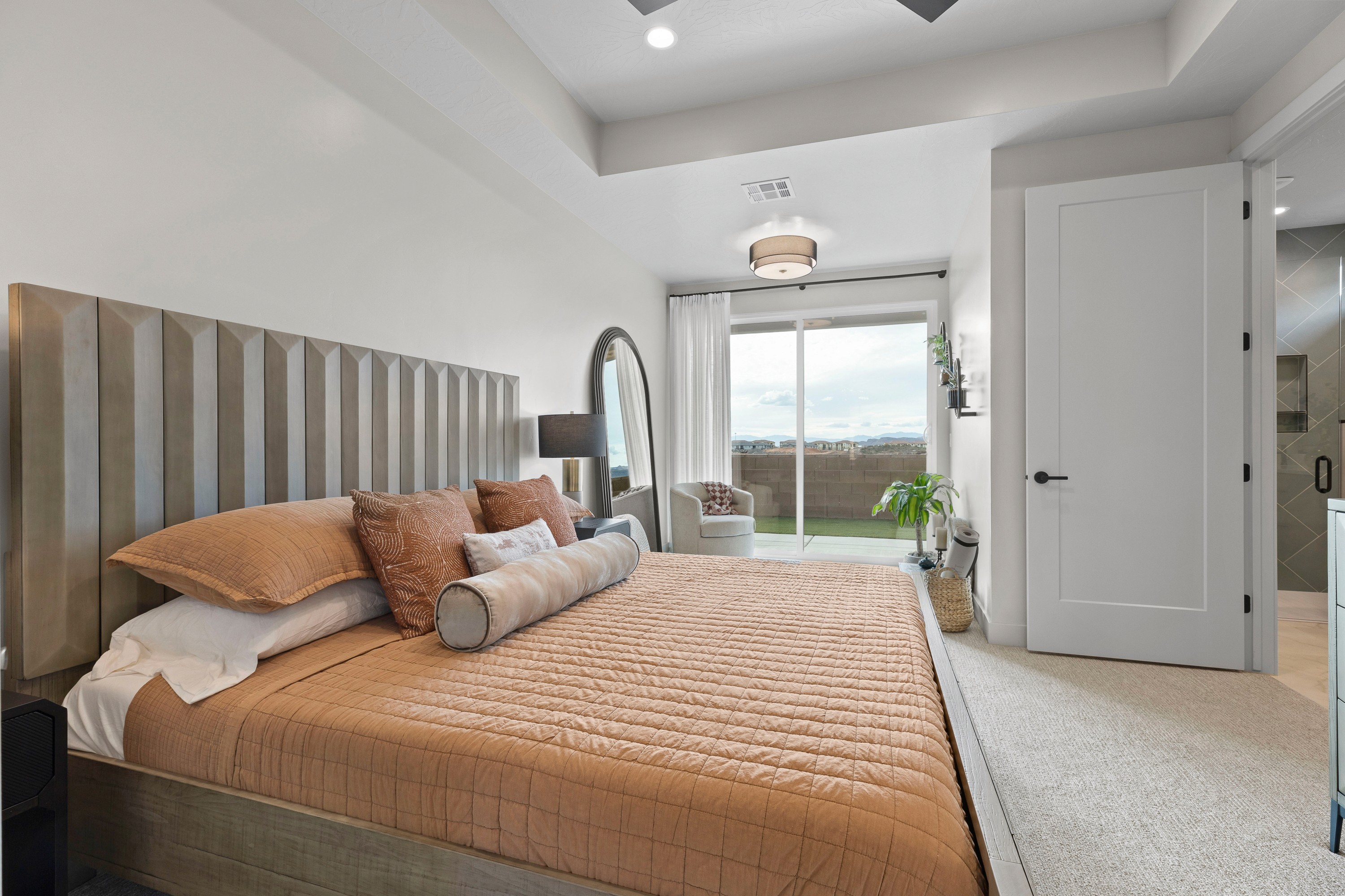Master bedroom with drape window coverings in a Hurricane, Utah custom home.