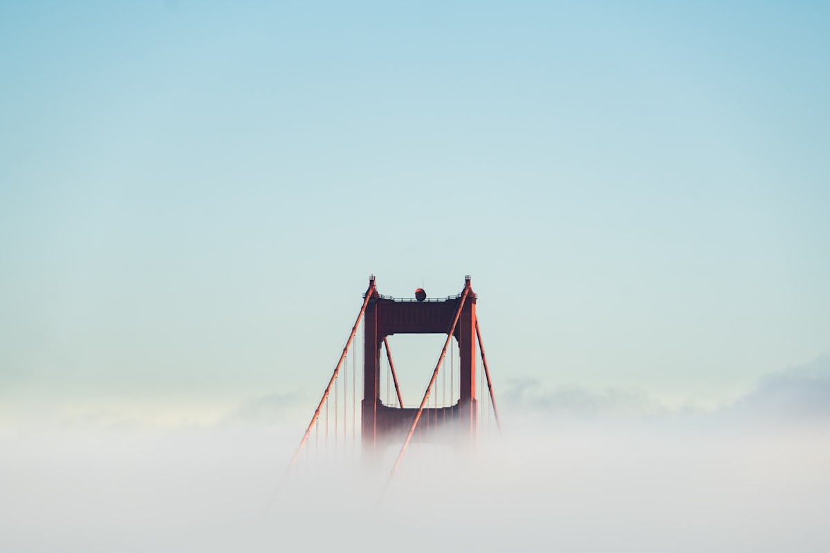 Golden Gate Bridge half-hidden in summer fog over the bay