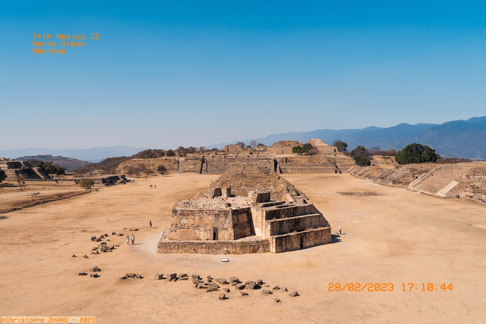 Vue panoramique des ruines de Monte Albán au Mexique sous un ciel bleu clair.