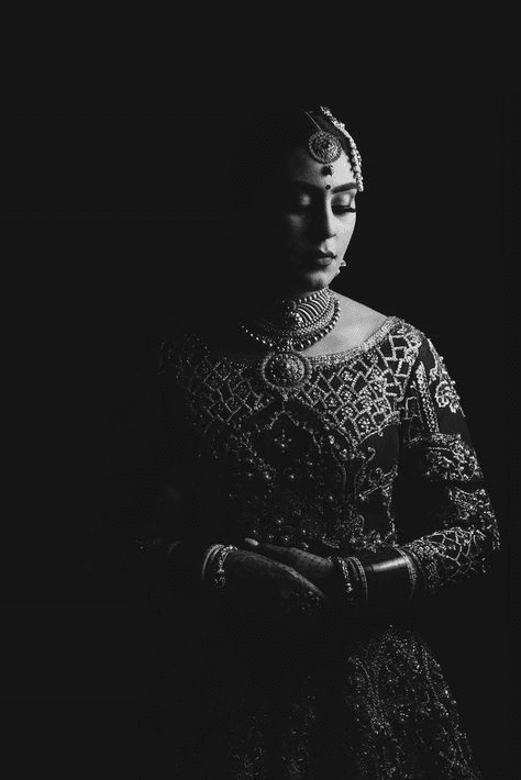 Classic and moody black and white portrait of a bride in traditional attire, focusing on intricate details and emotional depth, ideal for dramatic wedding photography.