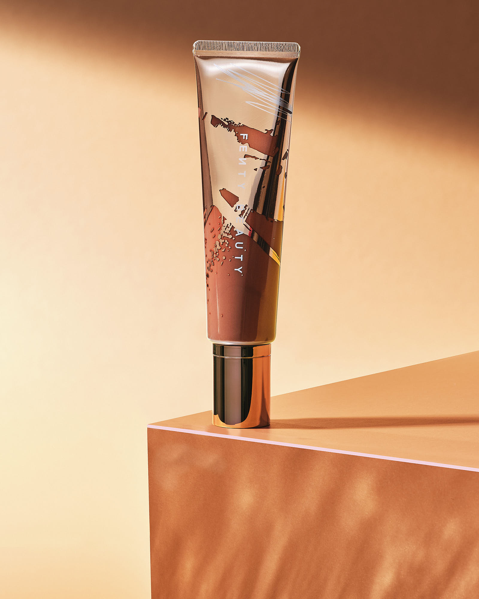 A cosmetic tube stands upright on a wooden surface, with a soft orange background.