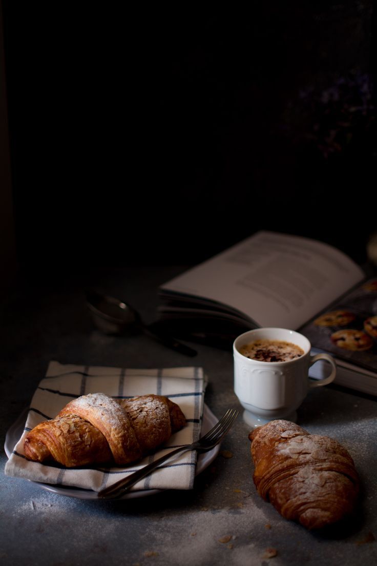 Fresh baked croissants dusted with powdered sugar served alongside a hot espresso at Café Sherpa's, a globally inspired café in Brookfield, WI. Made throughout the day, best enjoyed in the moment.