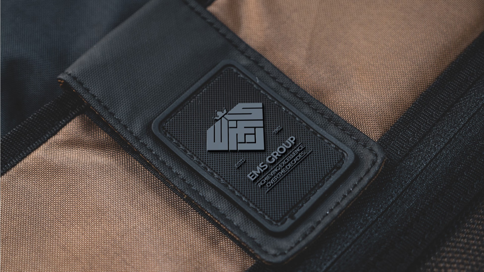 EMS Group branded patch on luxury bag — Penguincil Design
