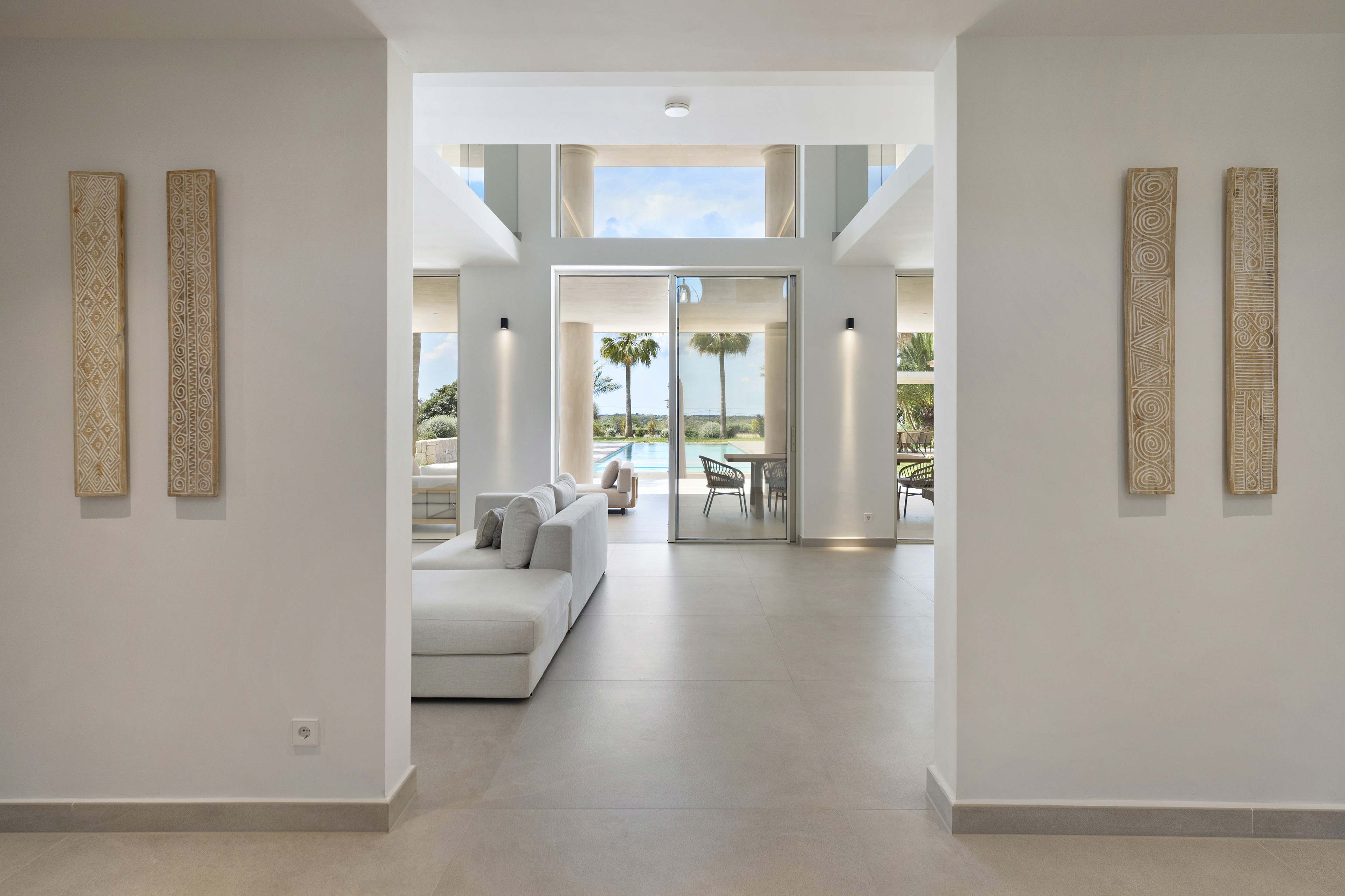 Innenbereich der Villa in Llombards auf Mallorca mit klarer Architektur, Naturtönen und Blick in den Aussenbereich
