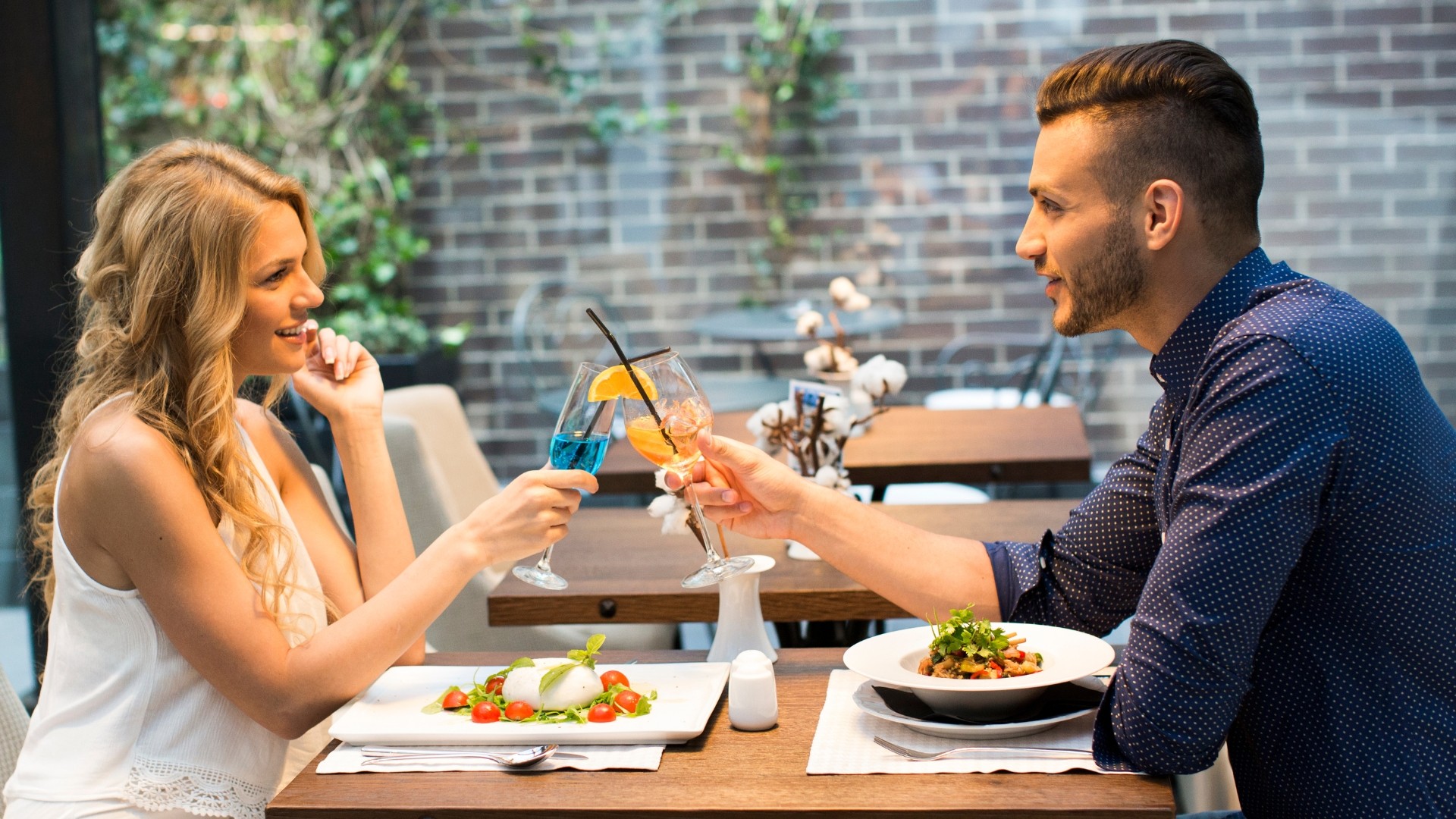 ein mann und eine frau in einem restaurant, sie stoßen an