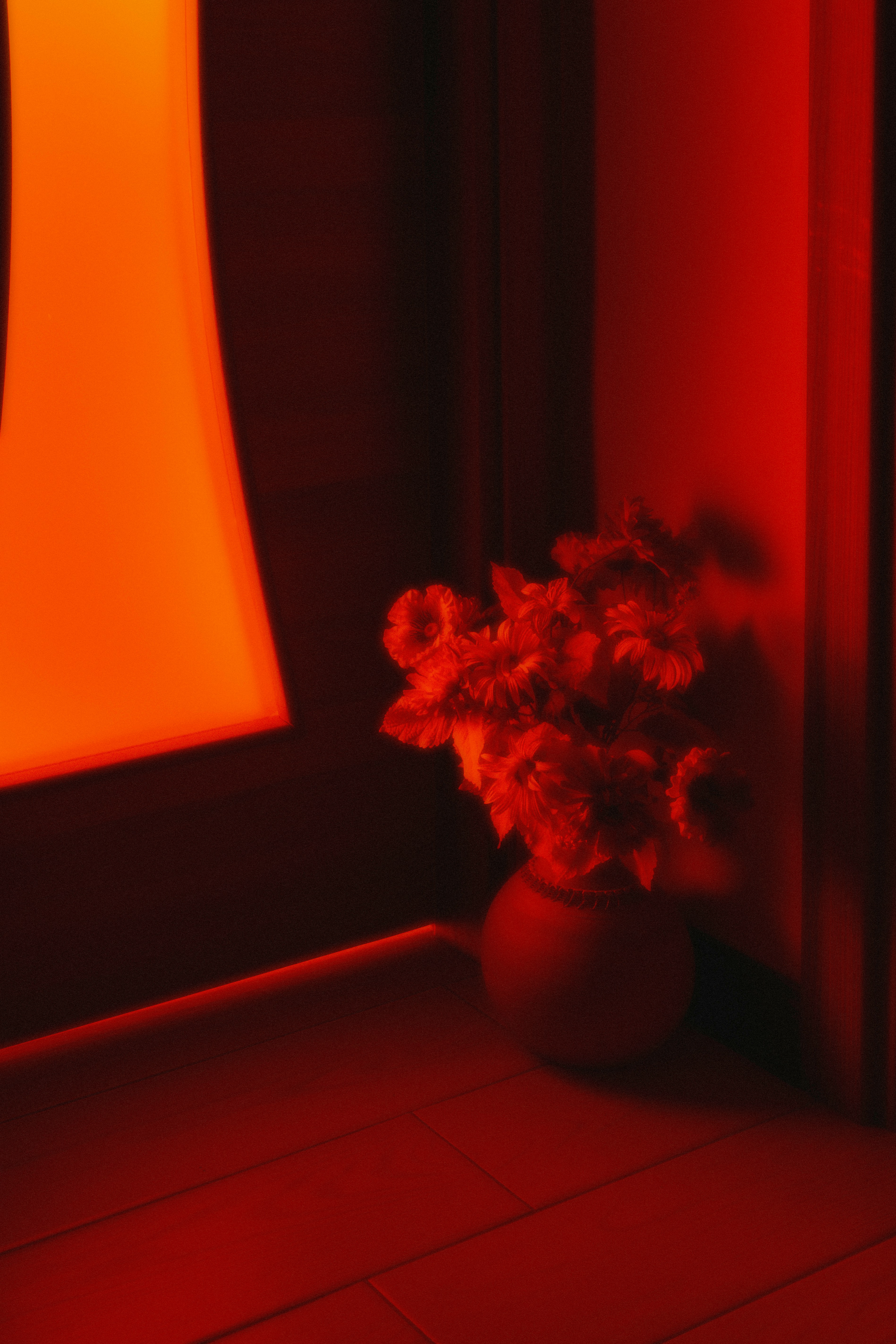 a vase filled with flowers sitting on top of a tiled floor