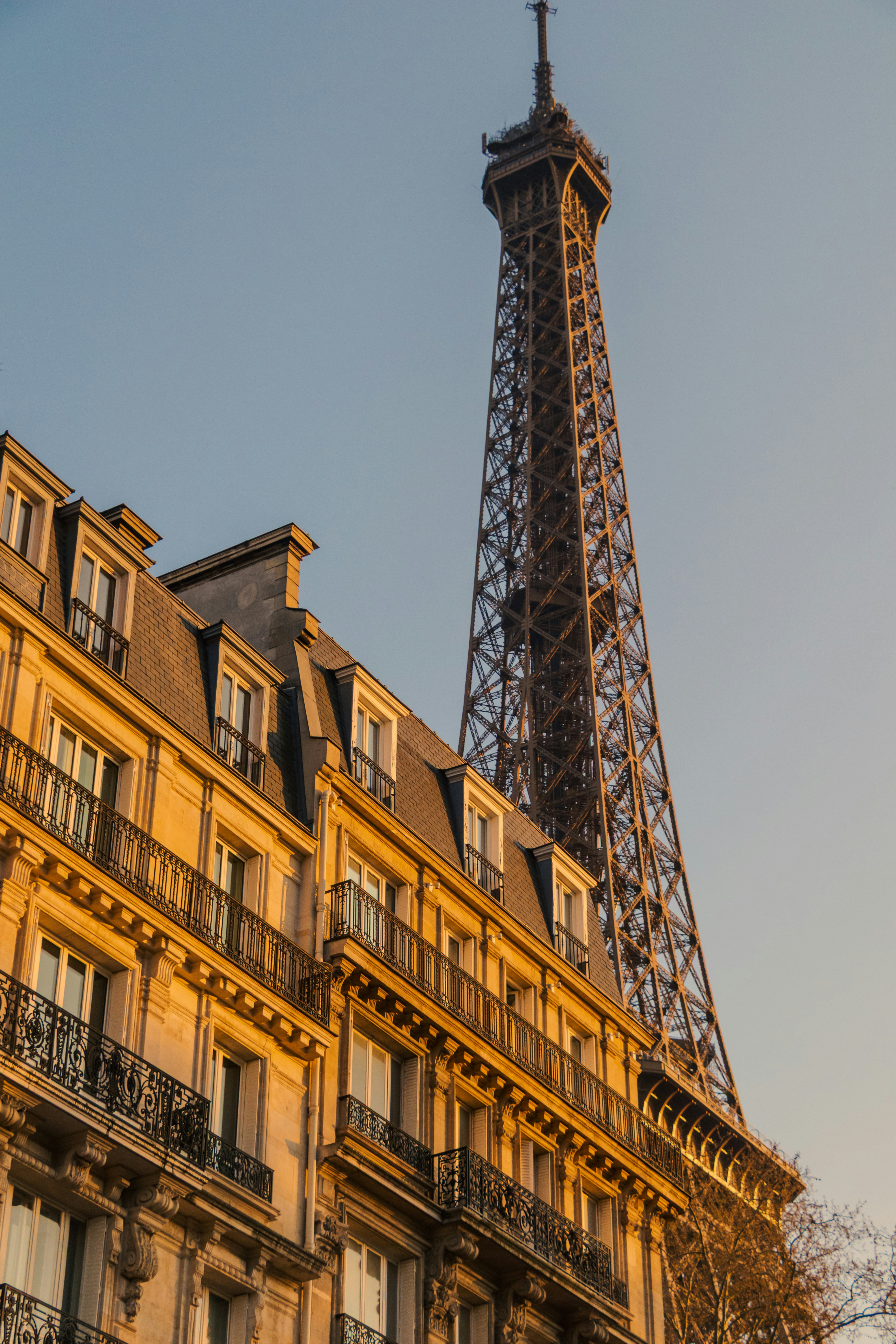 Eiffel tower behind a parisian building at sunset