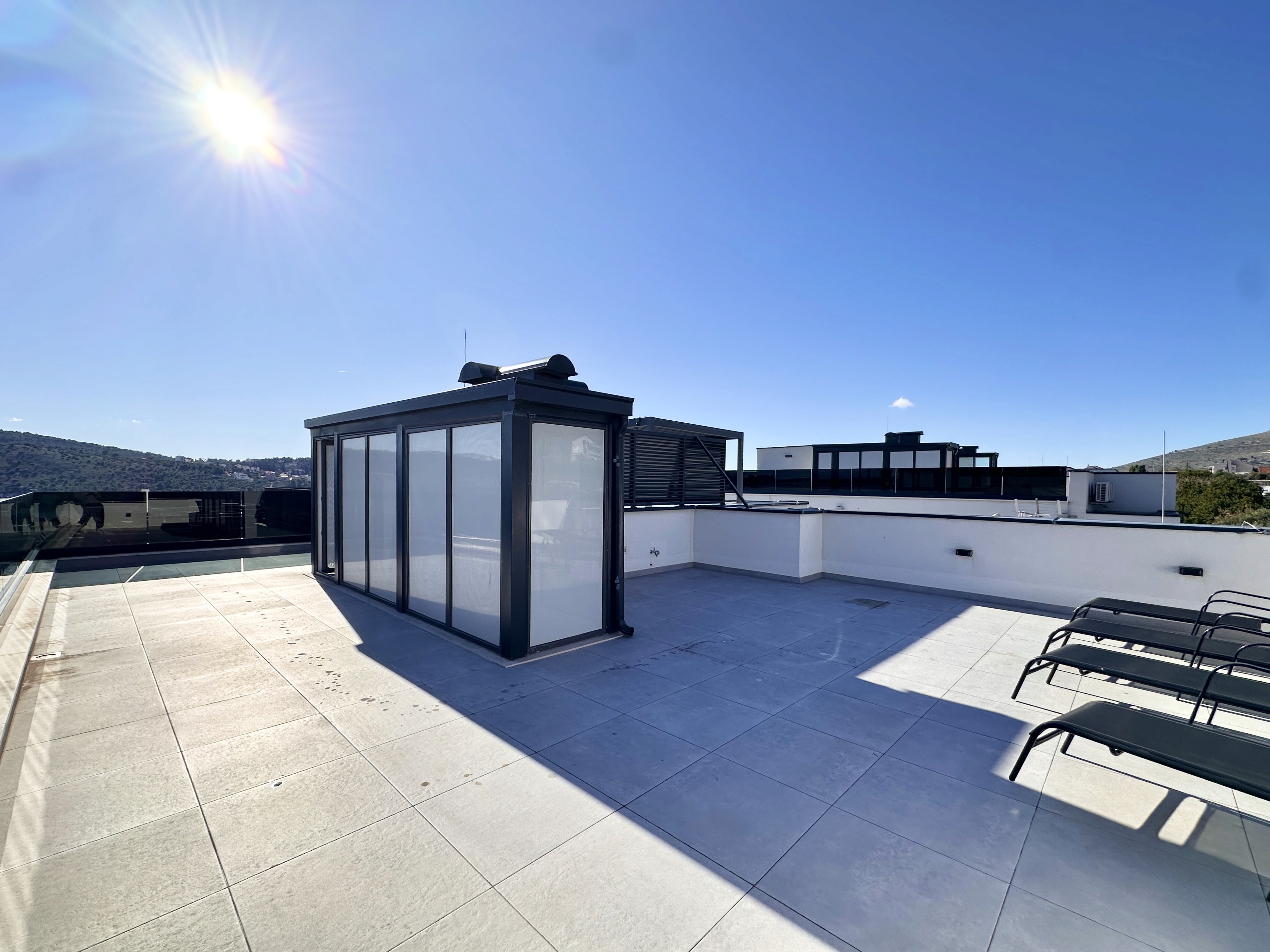 Minimalist dining room with wood table and woven ceiling lights.