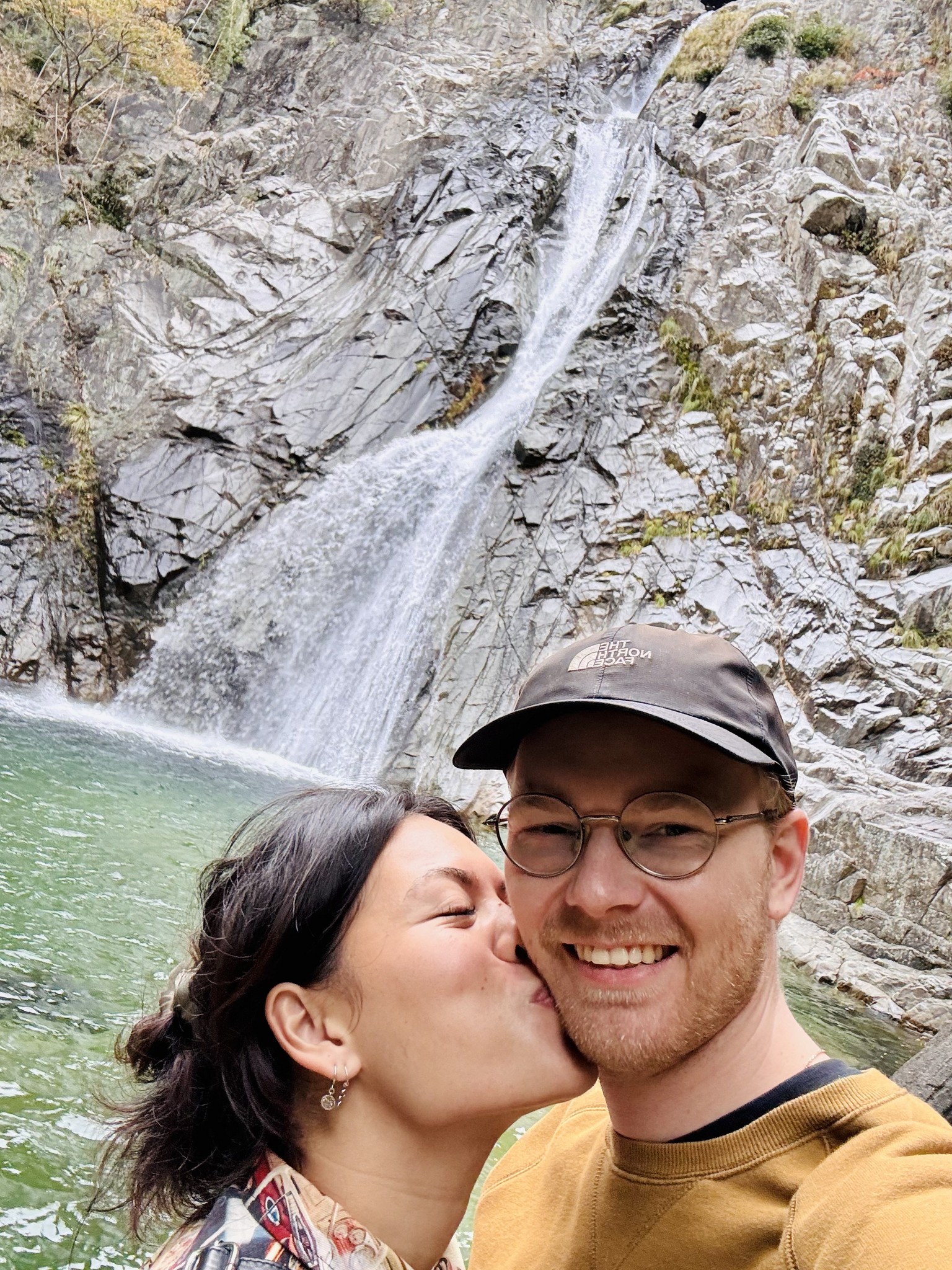 A serene pathway lined with trees leads to a distant building, bathed in warm sunlight.