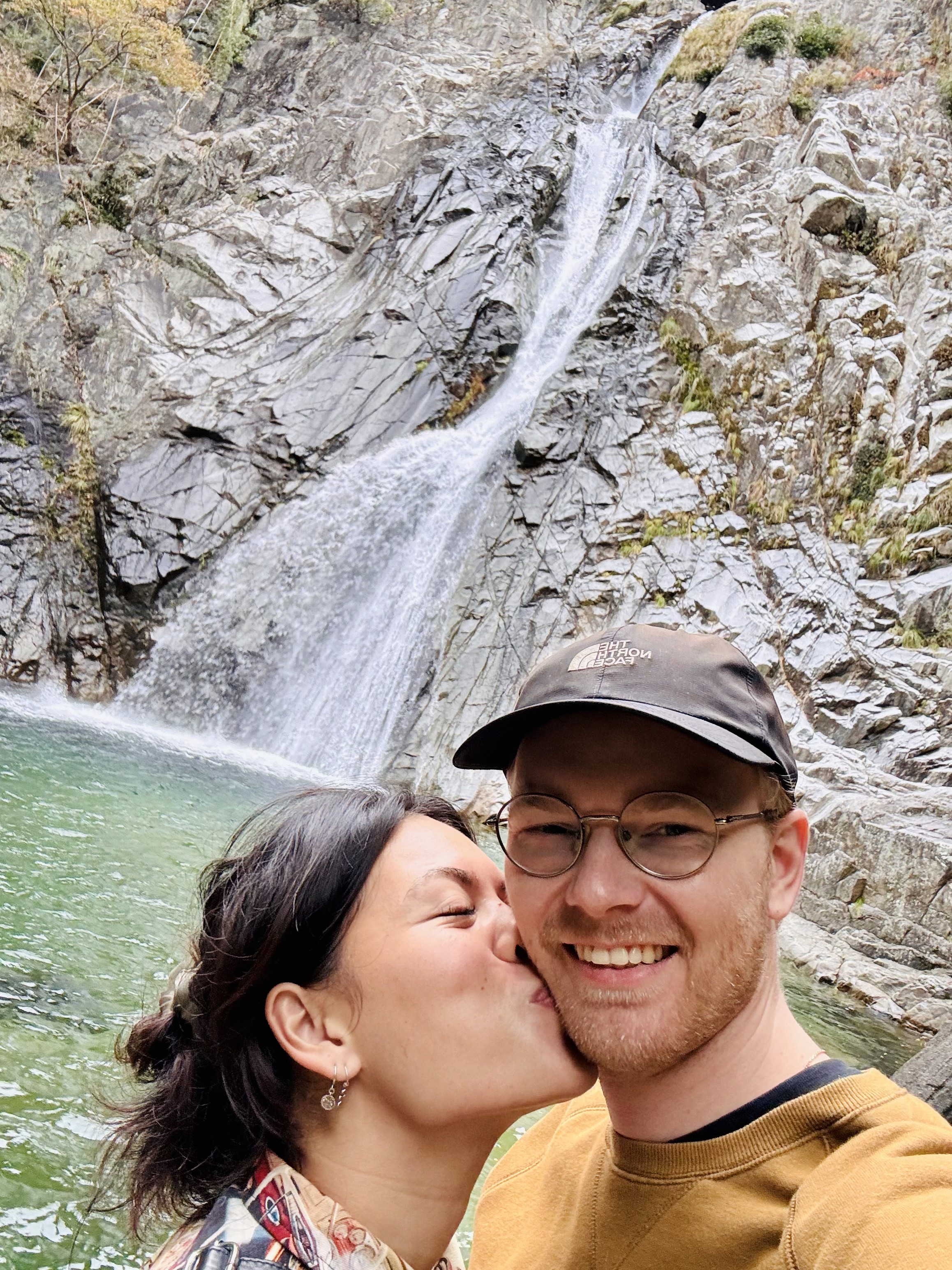 A serene pathway lined with trees leads to a distant building, bathed in warm sunlight.