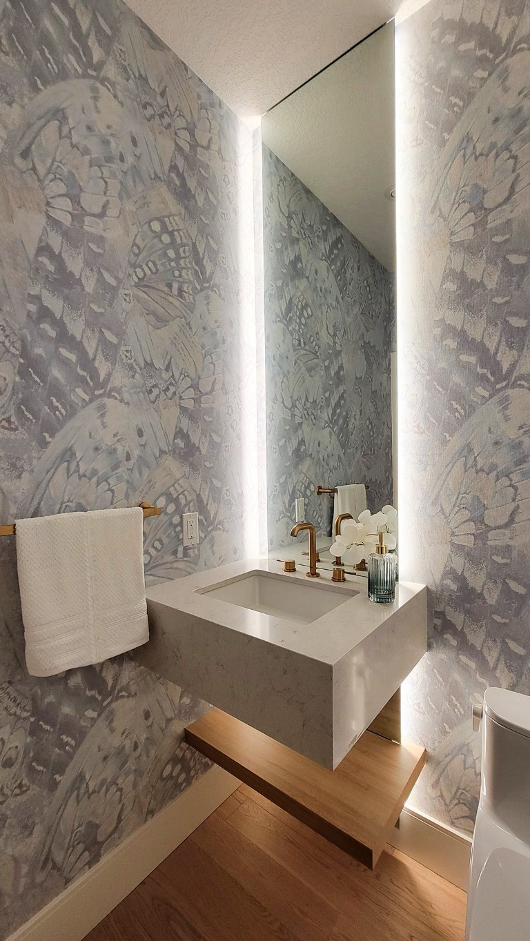 Image of Luxury bathroom design by KHD Homes featuring a marble sink, wallpaper, and modern construction elements.