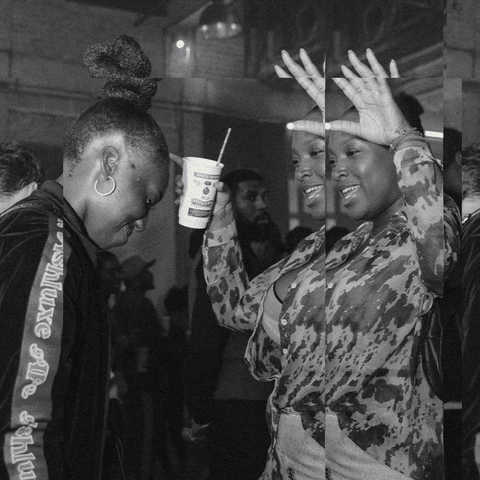 Close-up of hand holding pink ice cream cone against pastel background