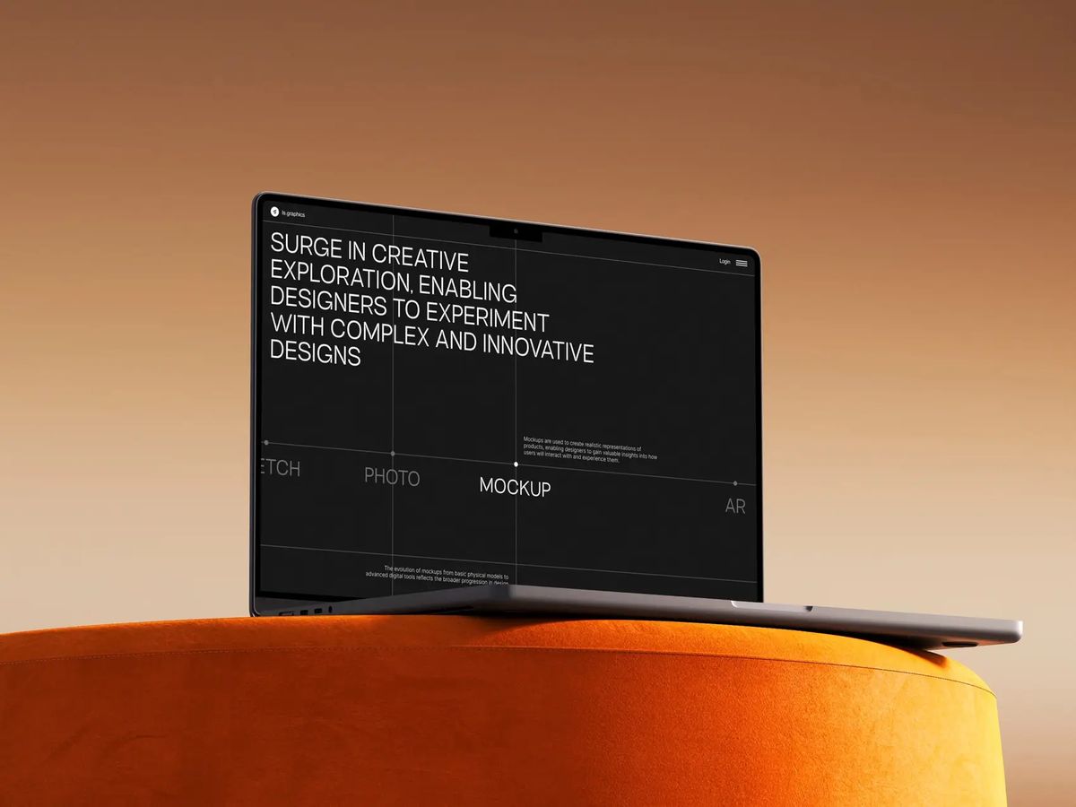 Dark website design mockup on a laptop, resting on an orange surface.