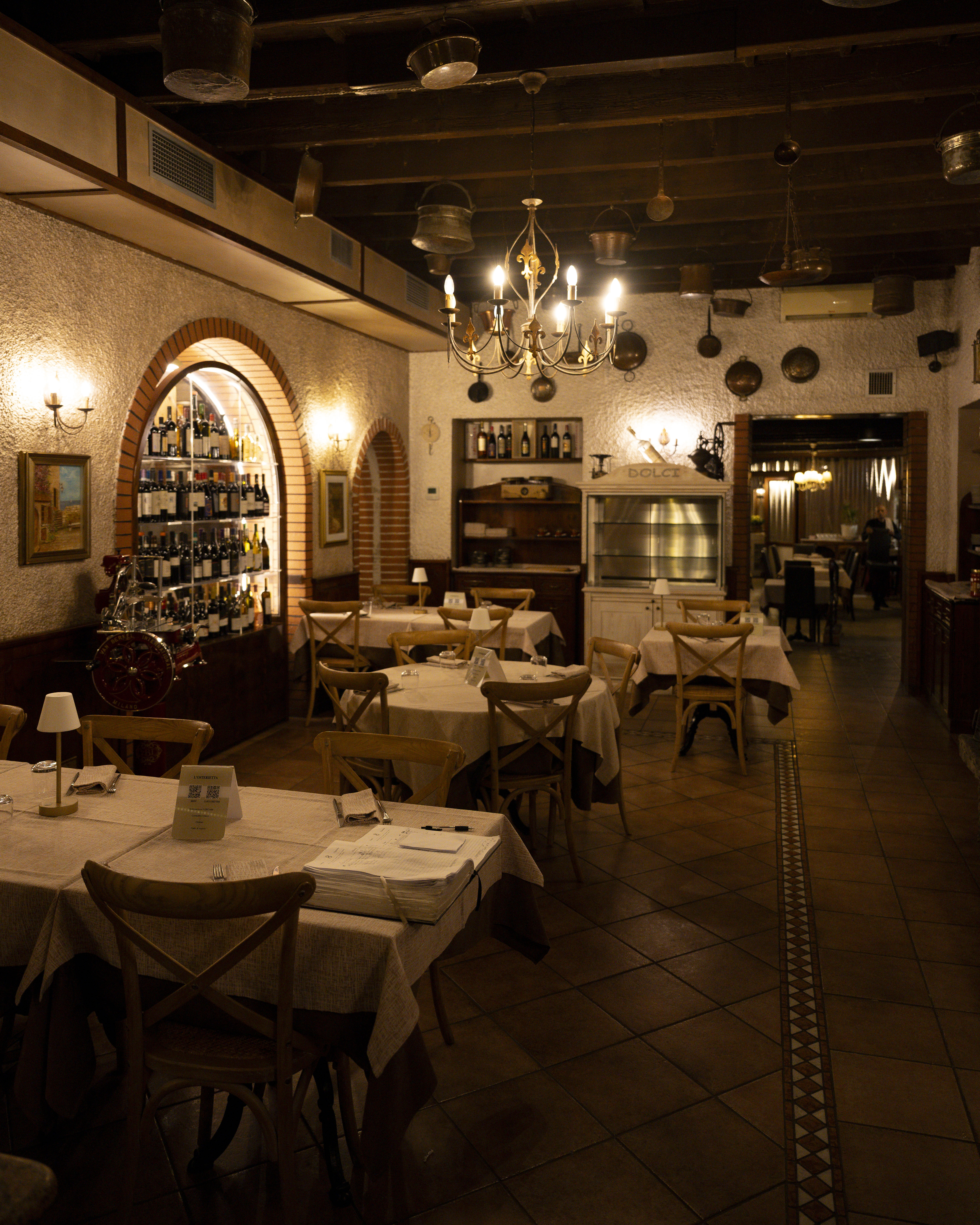 Restaurant bar with guests seated at tables and bartenders at work.