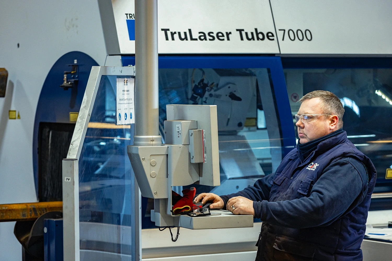 CASC employee operating a TruLaser Tube 7000 machine during precision tube laser cutting.