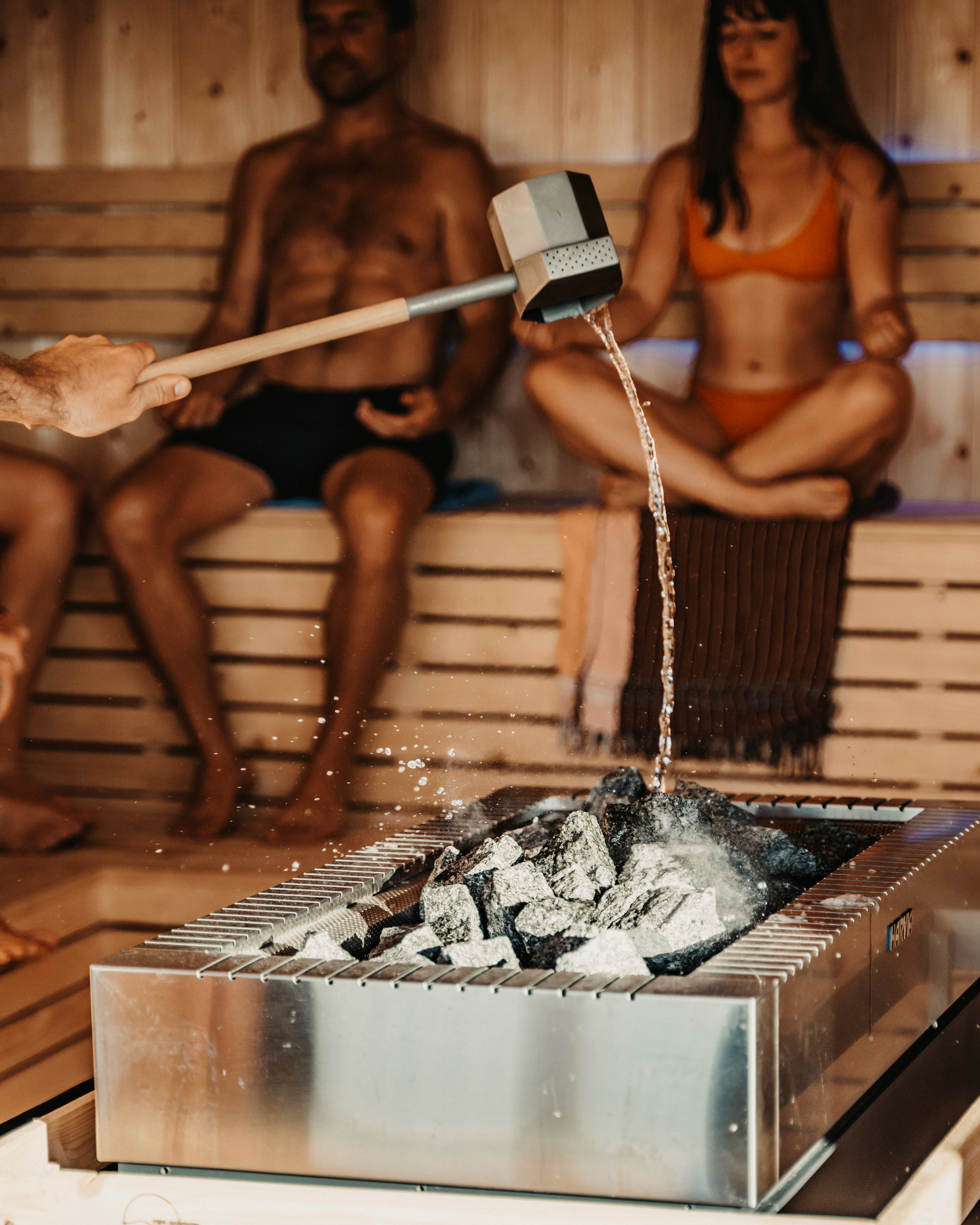 Guided Saunagus heat ritual at SaunaHaüs Cape Town, with water being poured over hot stones inside the sauna.
