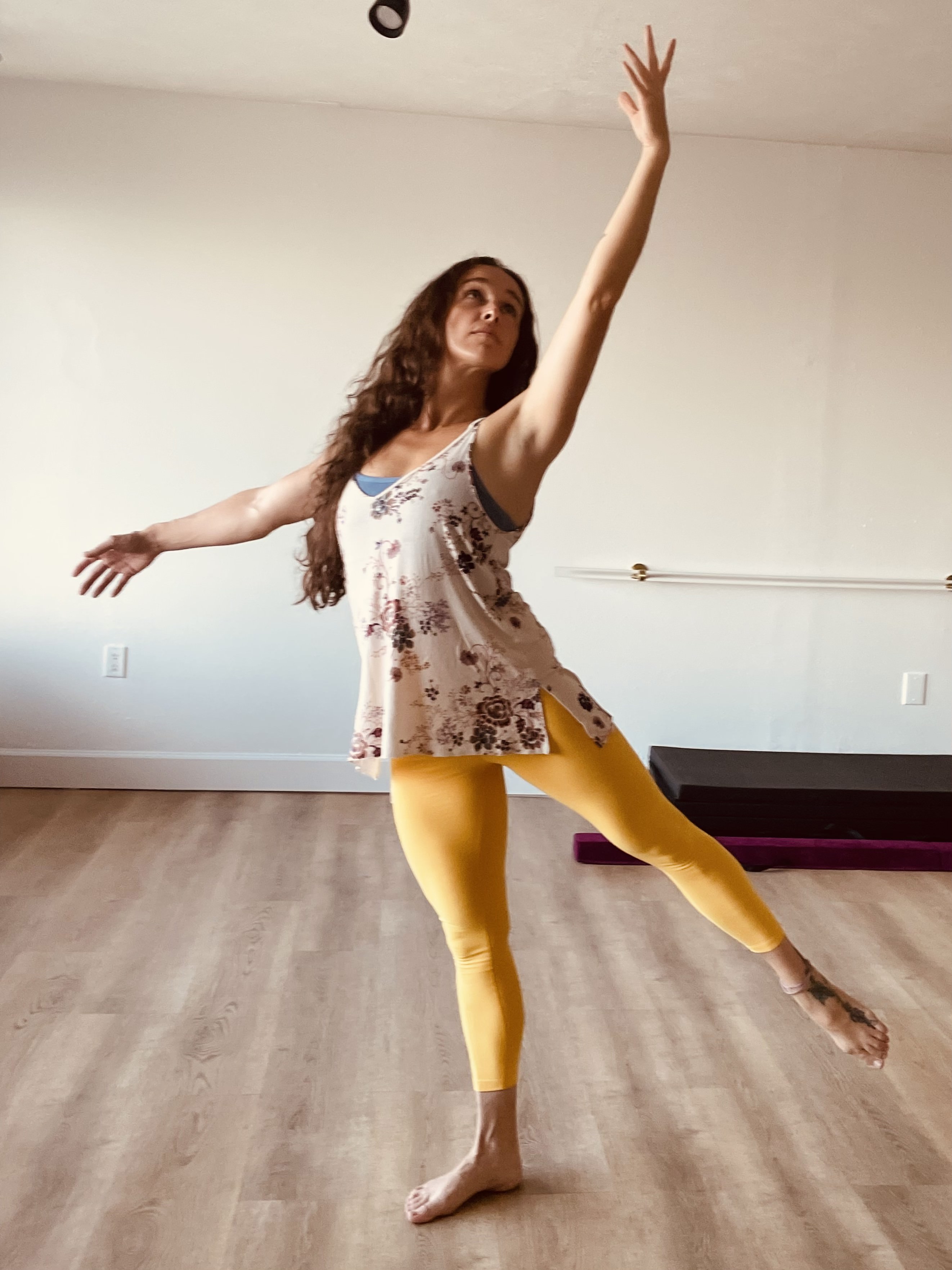 woman in black tank top and purple leggings doing yoga on green grass field during daytime