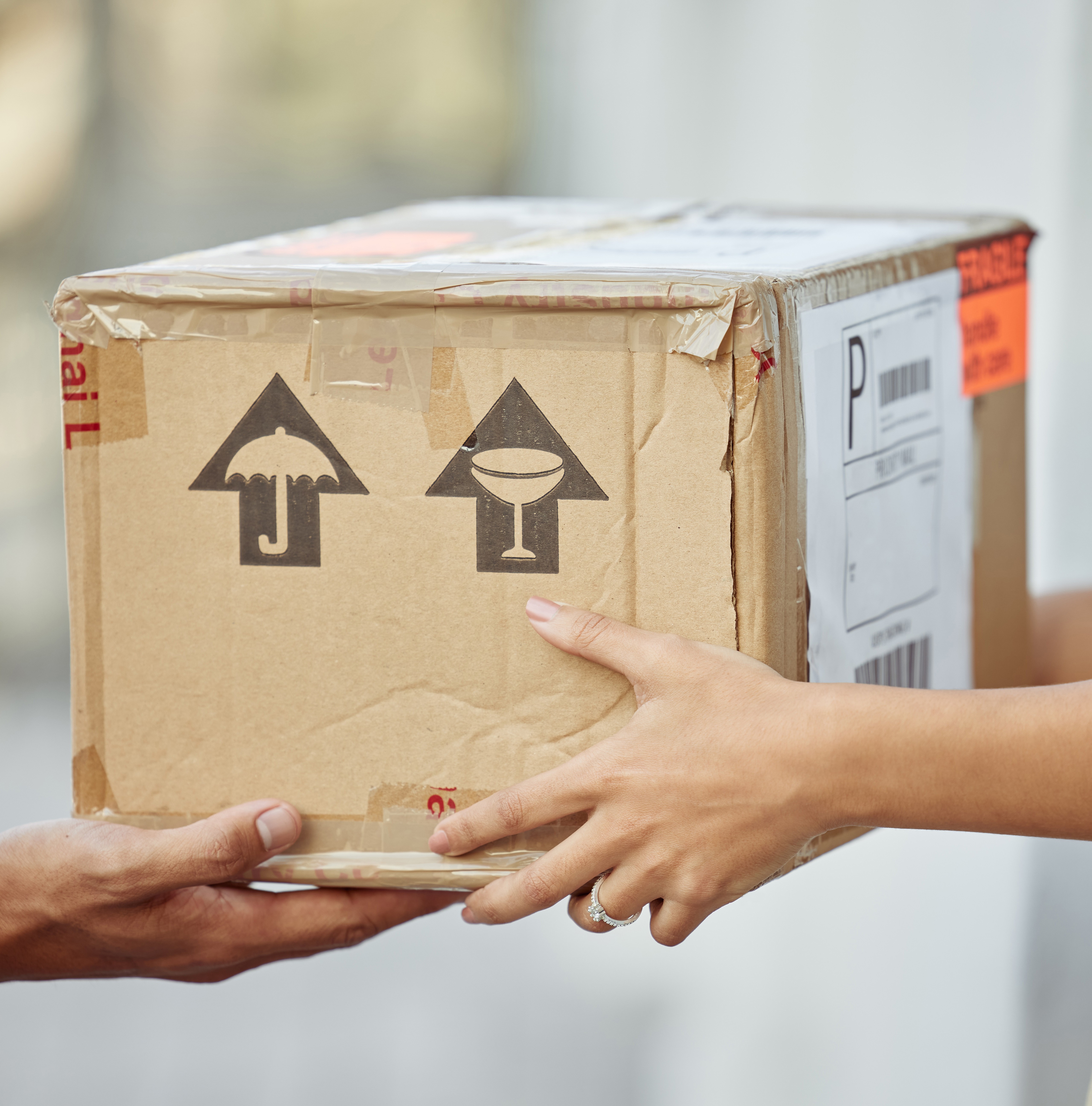 a woman handing a cardboard box to a man