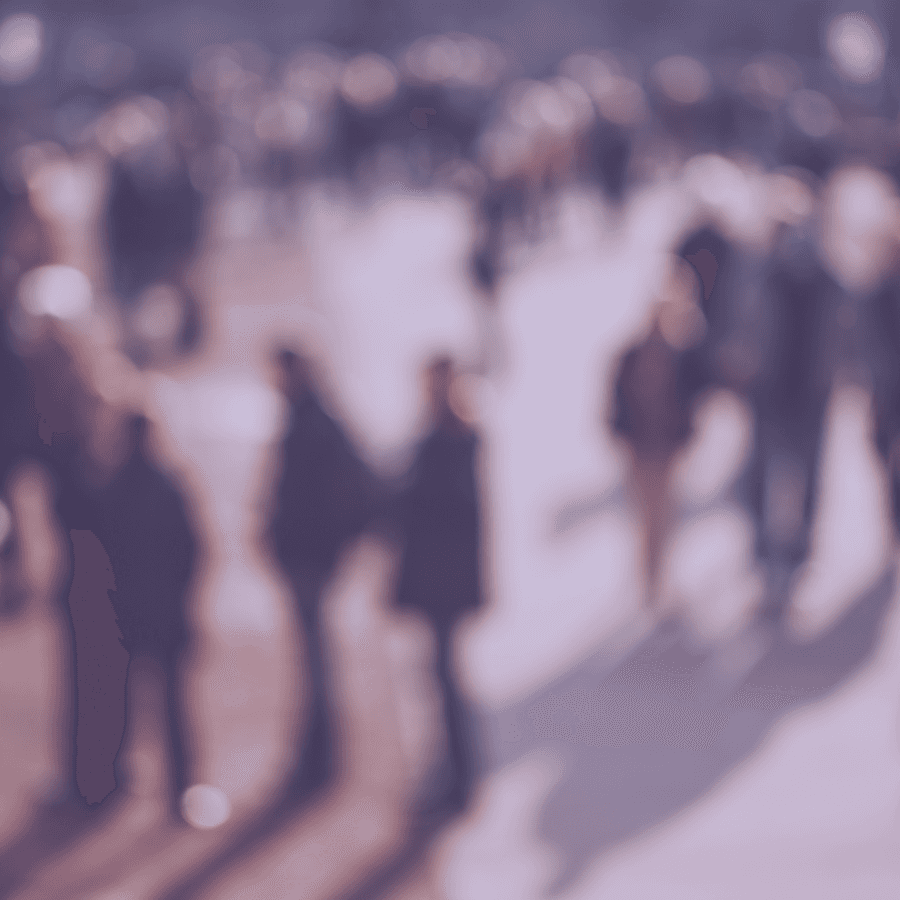 Photograph of a blurred crowd of people outdoors on a street used as illustration for the article People need people the recruitment crisis in clinical trials, by Clinials.