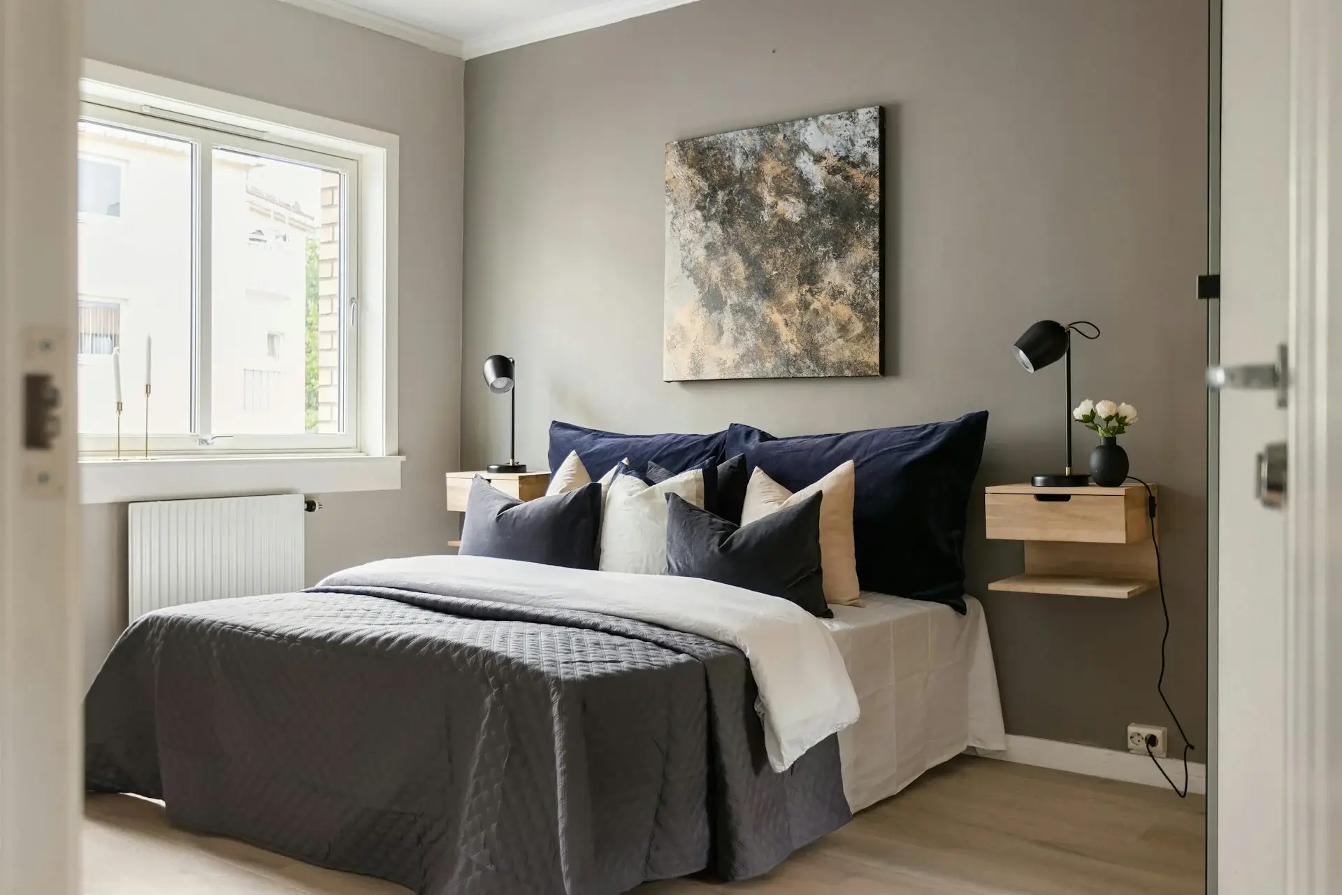 Cozy living room with gray sofa, soft cushions, warm lighting, round tables, and minimalist decor.