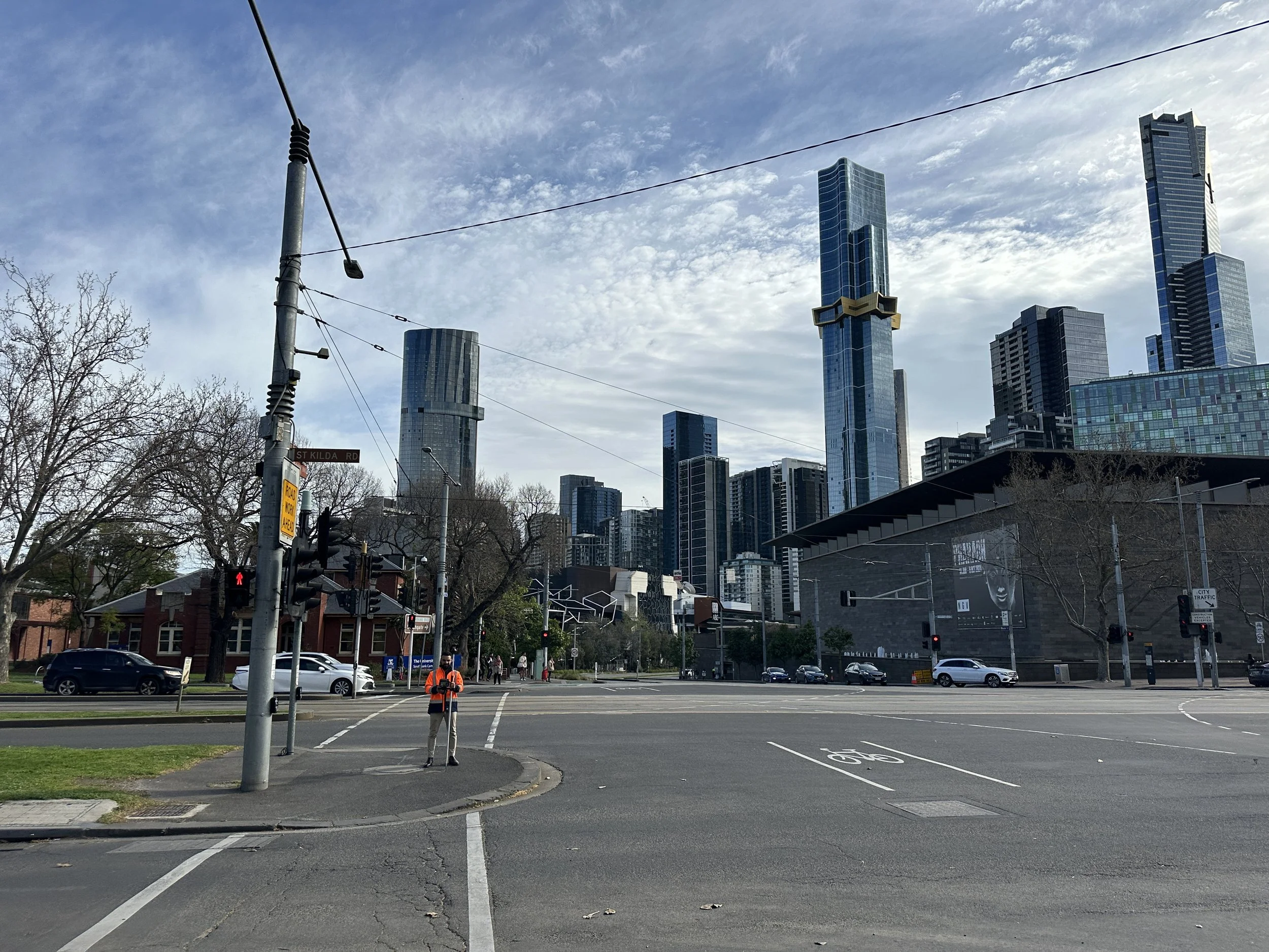 A licensed surveyor with professional surveying equipment in the middle of a Melbourne City street