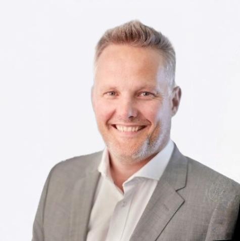 Headshot of employee, Steen Wæver Poulsen, on a blue tinted, grey background