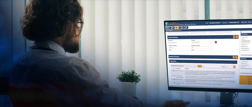 Two individuals working at computer stations, with code displayed on large monitors—representing cybersecurity operations or secure software development in progress.