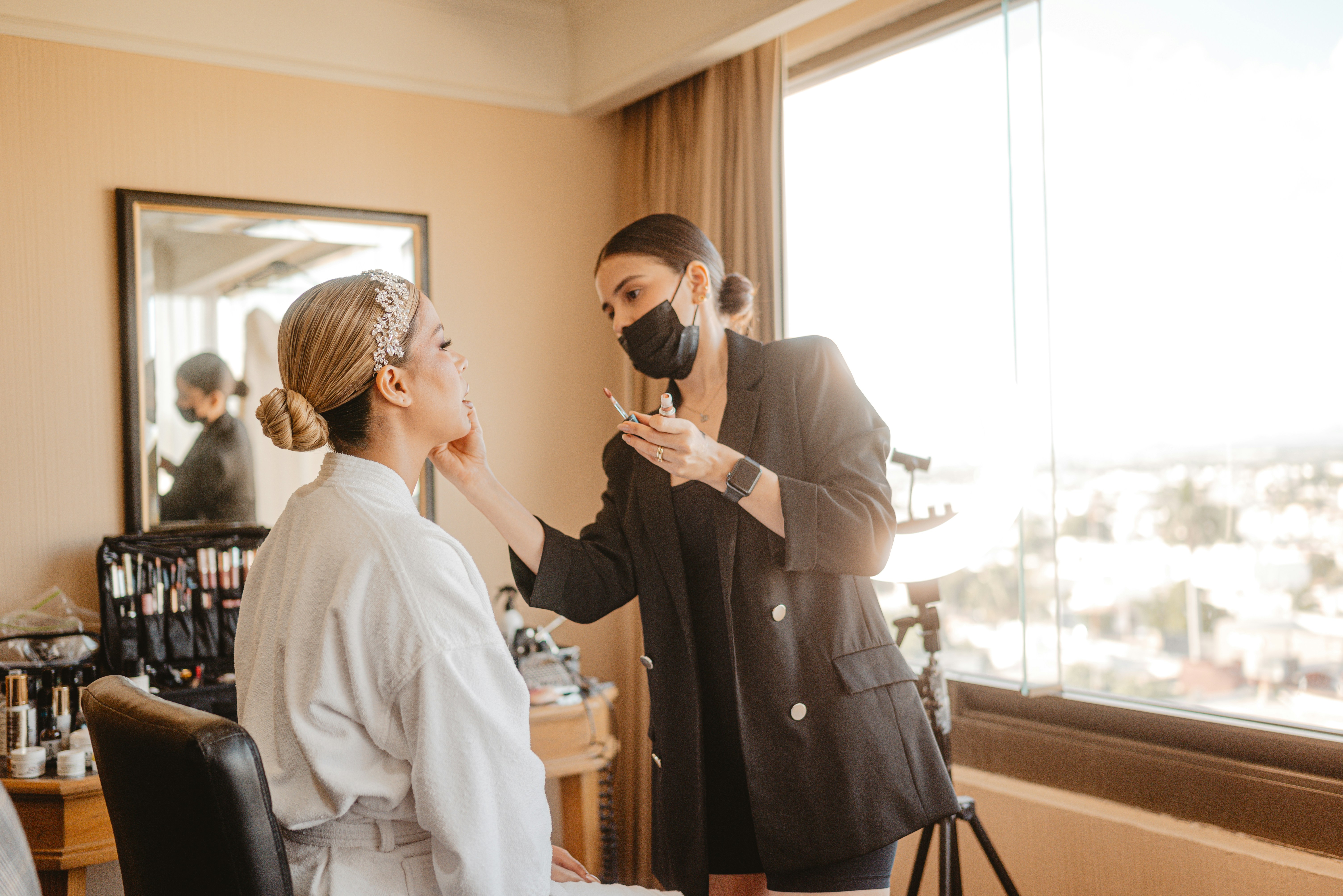 Bride-to-be getting her makeup done in a hotel suite.