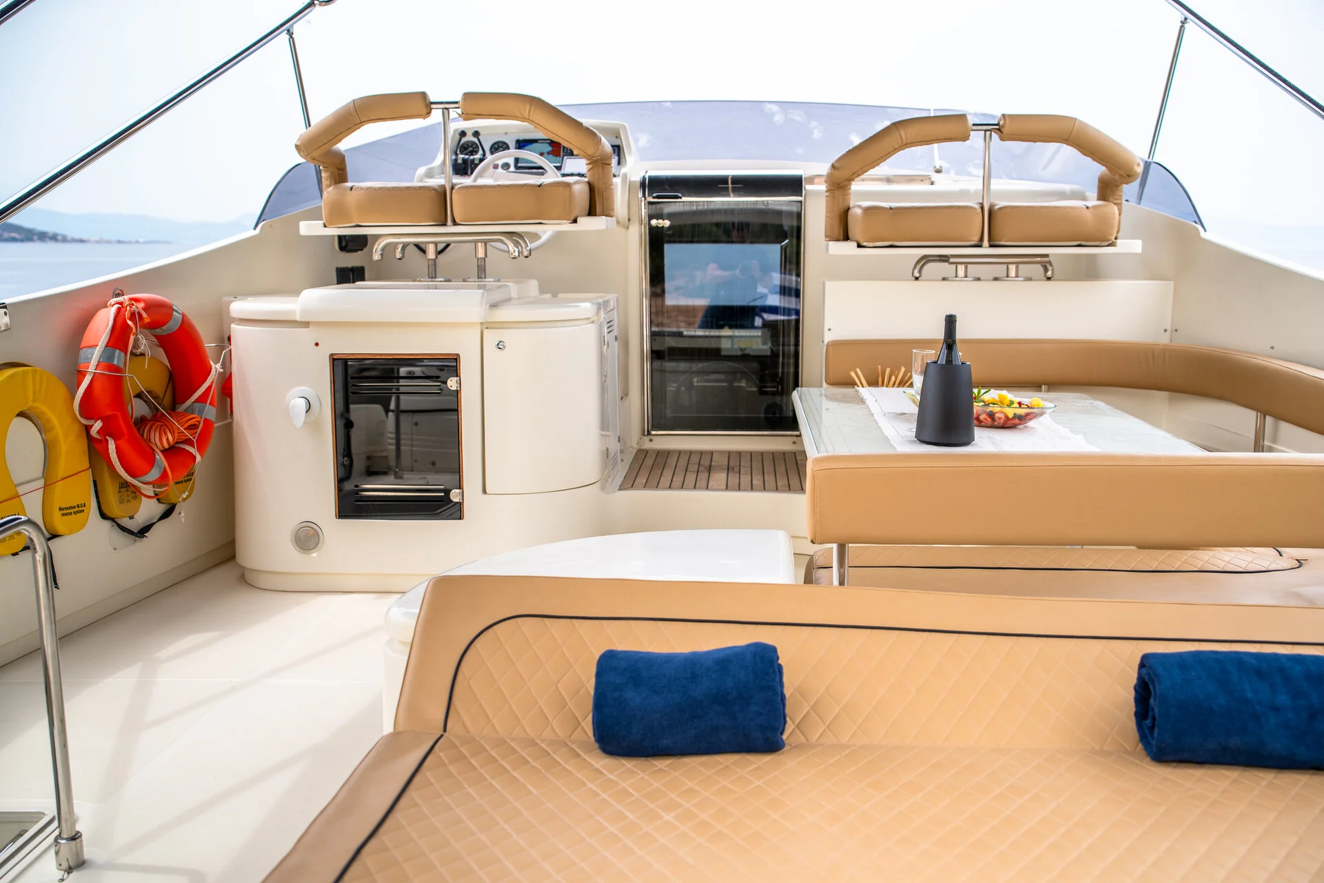White Rock 36 speedboat with captain at helm cruising calm blue waters near Paros coastline with hills in background.