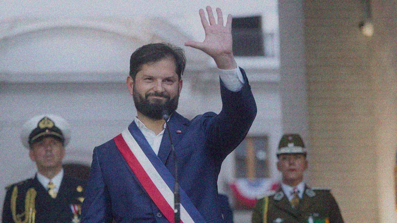 Foto del Presidente Gabriel Boric con la banda presidencial saludando en La Moneda en la columna de opinión La distancia entre lo prometido y lo cumplido de IdeaPaís.