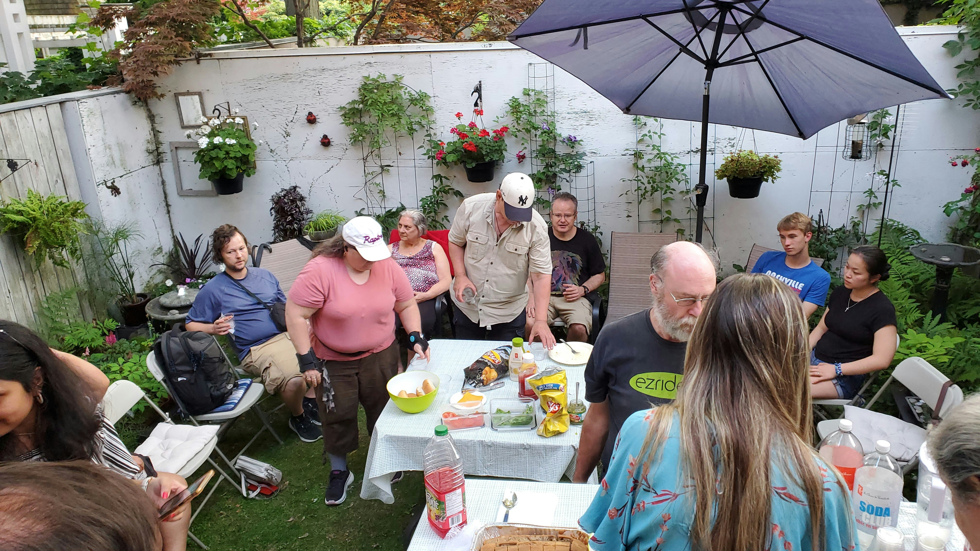 Friends gather for a party in an outdoor backyard.