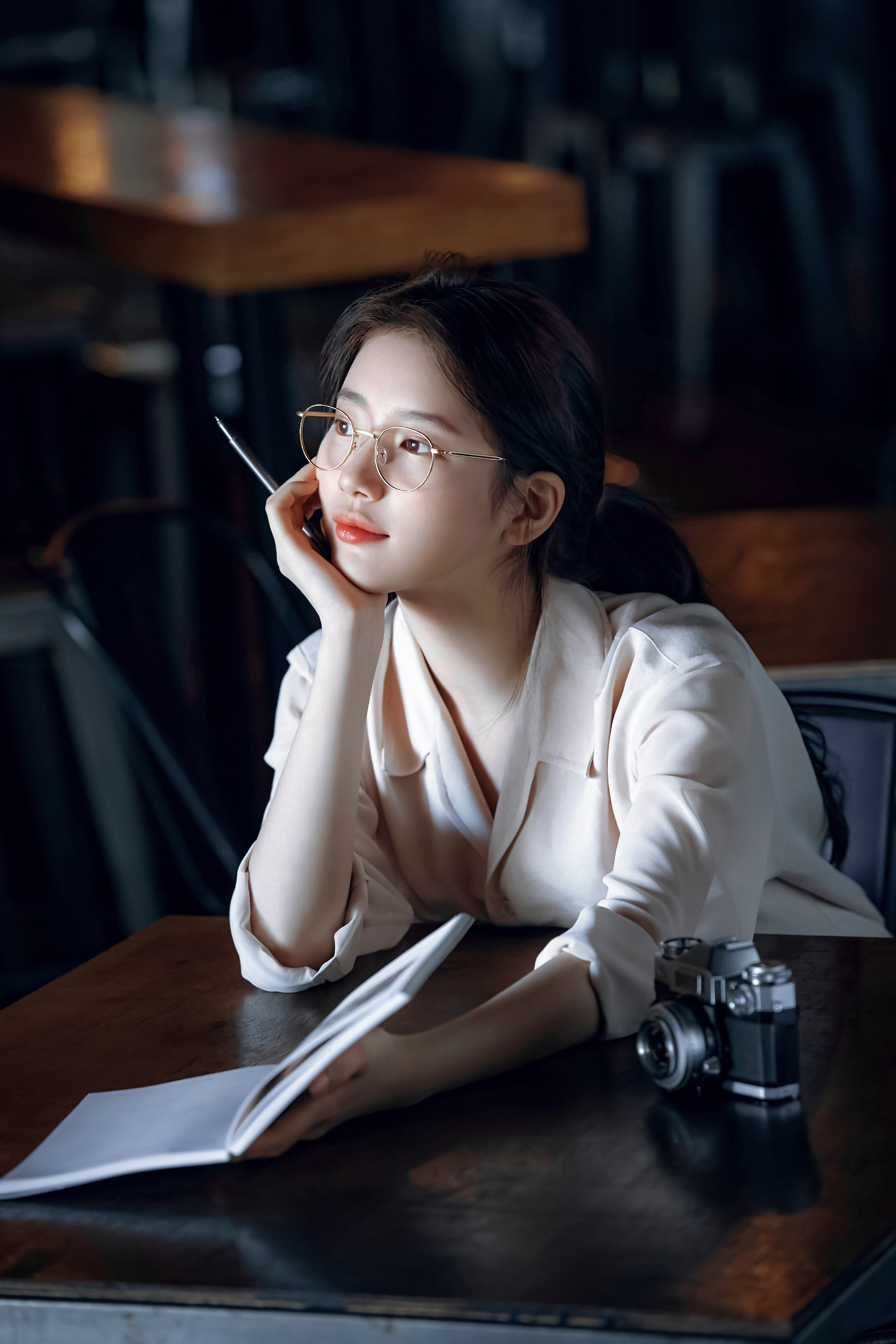 woman in white blazer wearing eyeglasses sitting by the table