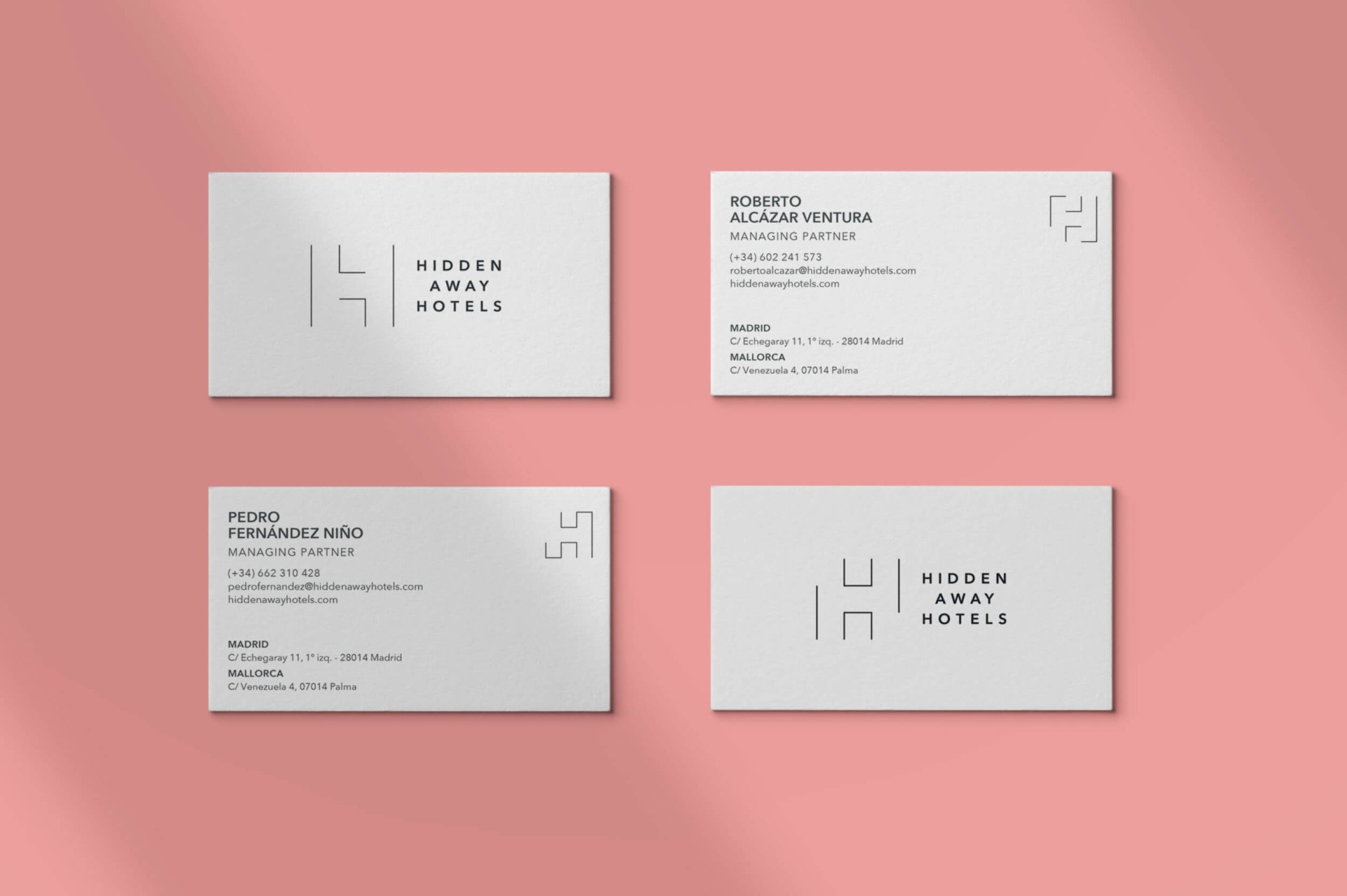 Tarjetas de presentación de Hidden Away Hotels sobre fondo rosado, diseño minimalista y elegante.