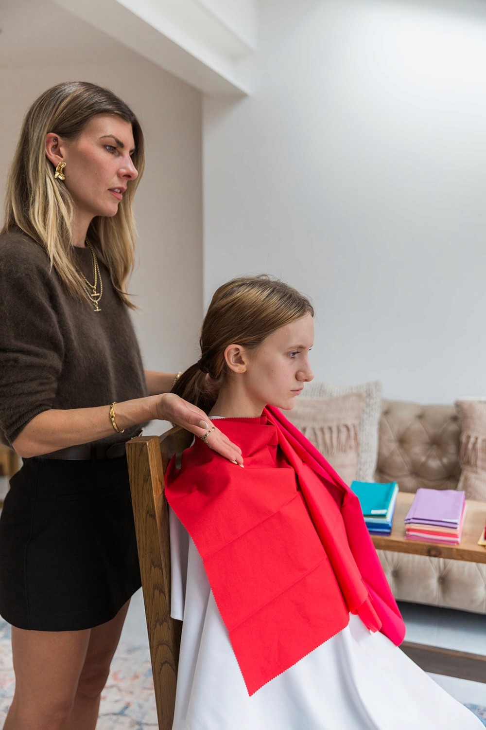 A girl being draped in red fabric