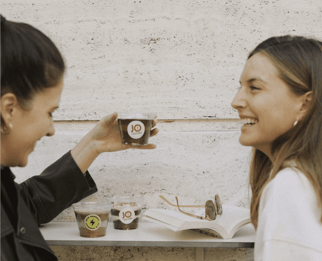 Friends enjoying Jo & The Sisters chia pudding and smoothie bowls during a relaxed morning coffee break