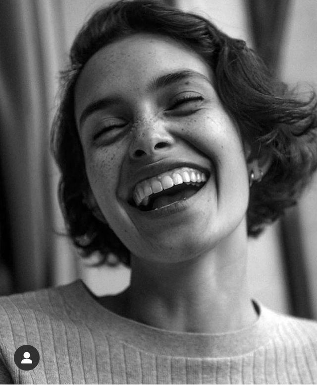 Junge Frau mit Sommersprossen lacht herzlich, Nahaufnahme