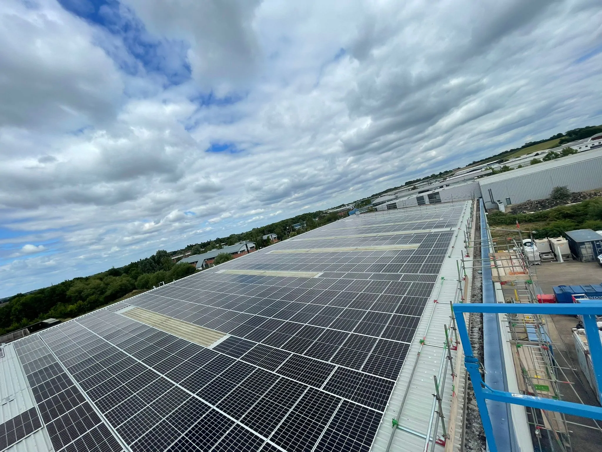 Aerial view of a large rooftop solar array on an industrial site