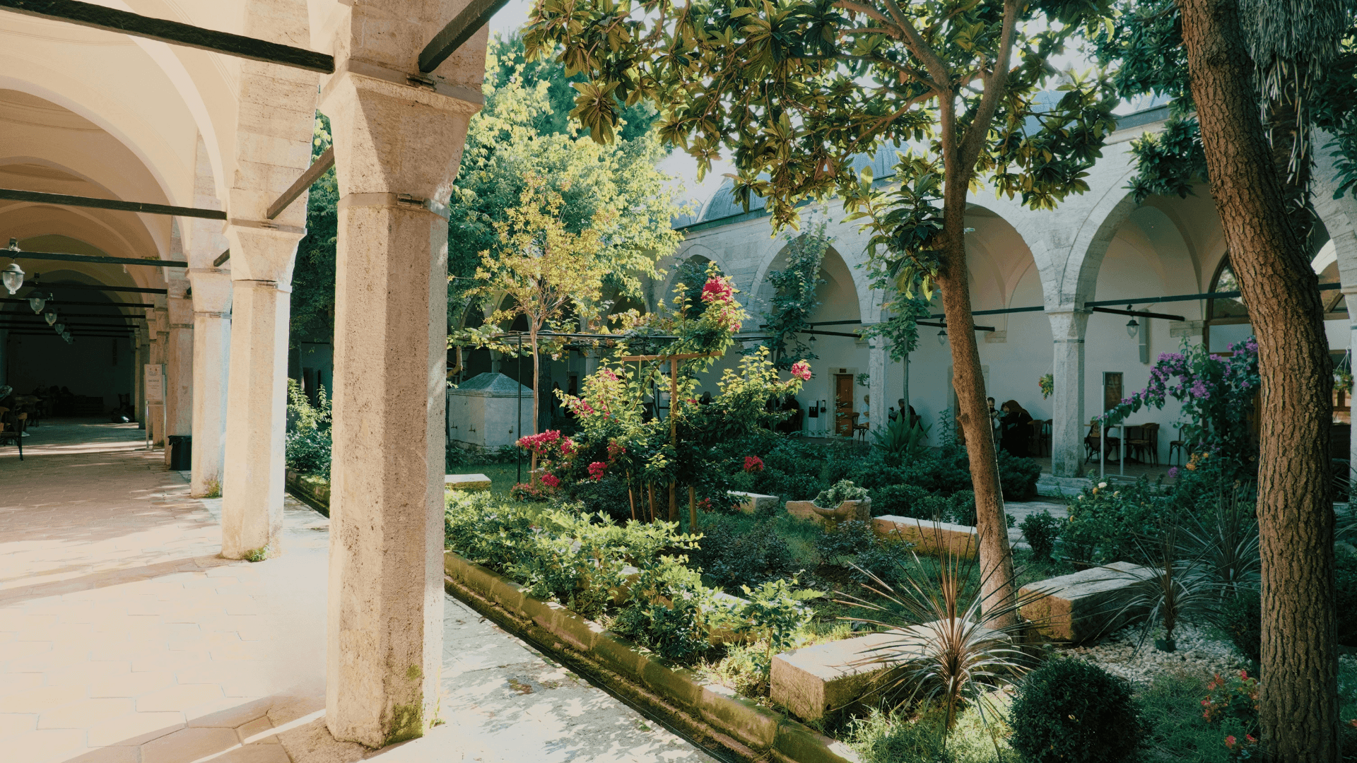 Peaceful Ottoman courtyard garden with stone arches and lush greenery in a historic Turkish imperial complex