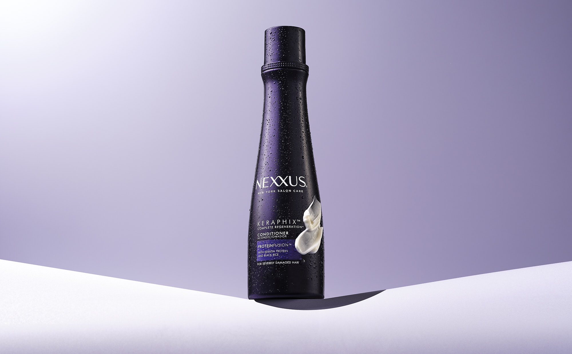 A sleek black bottle on a white surface with a soft purple background, showcasing a minimalist design.
